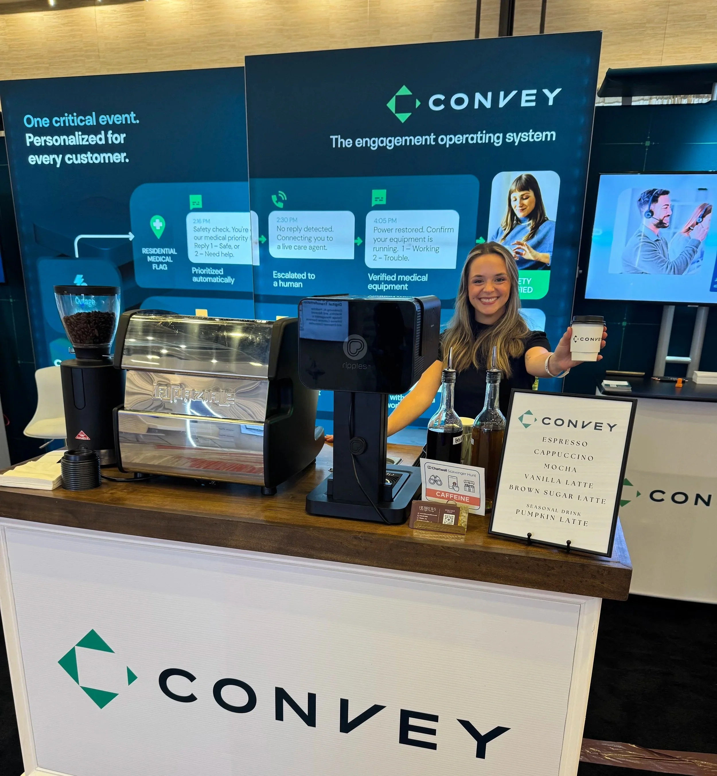 Hebrews Coffee Co. barista ready to serve at a branded espresso cart inside a conference exhibit booth