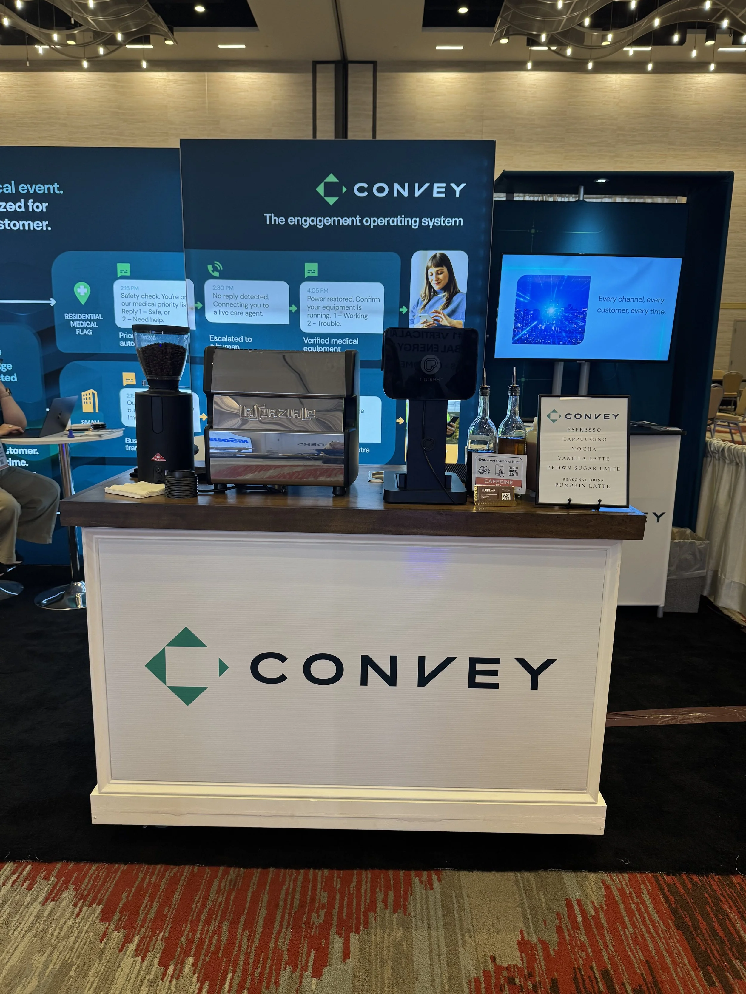 Custom-branded Hebrews Coffee Co. espresso cart serving guests inside a trade show exhibitor booth