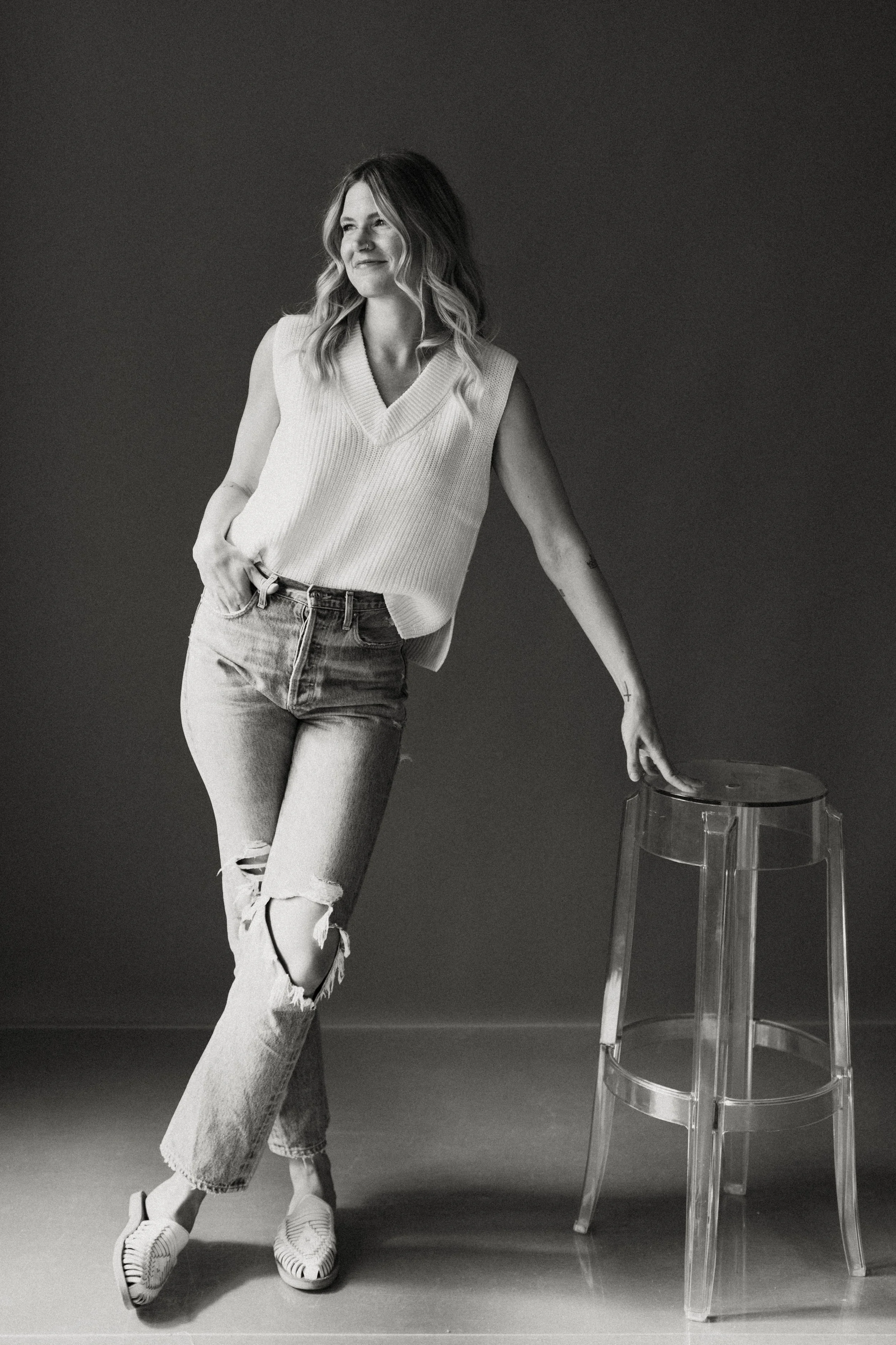 Chanelle Johnson standing beside a clear stool in a black-and-white portrait.