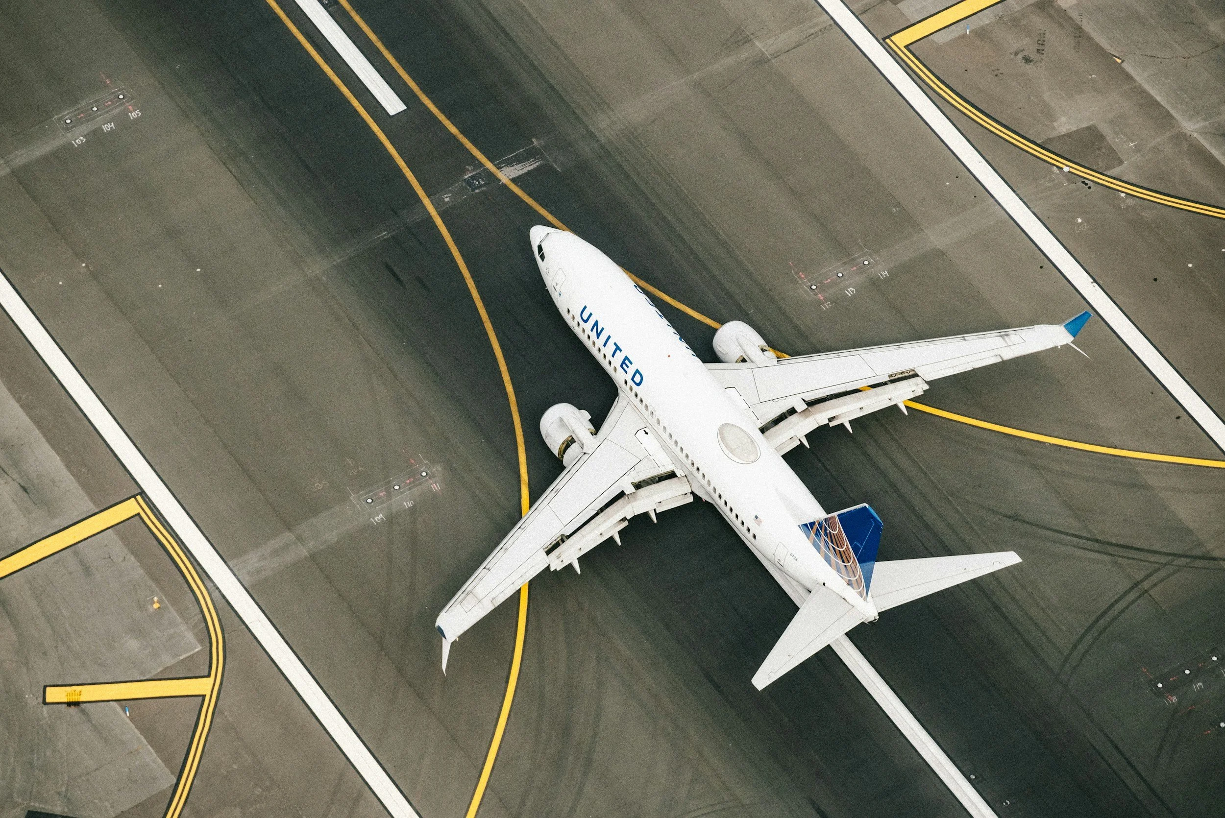 Top-down view of a United Airlines airplane parked at an airport gate.