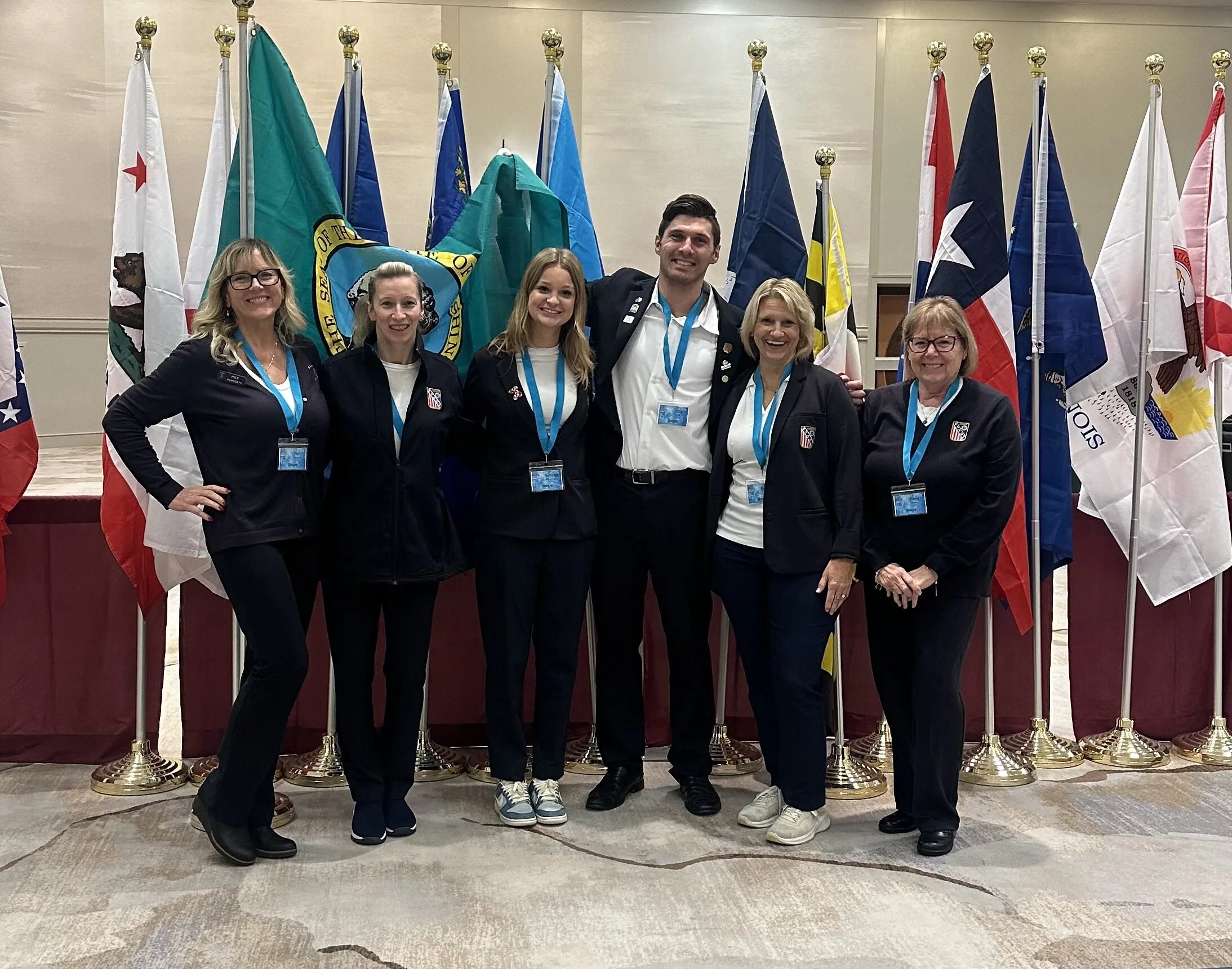 Group of WA judges pose for a photo in front of several different flags.