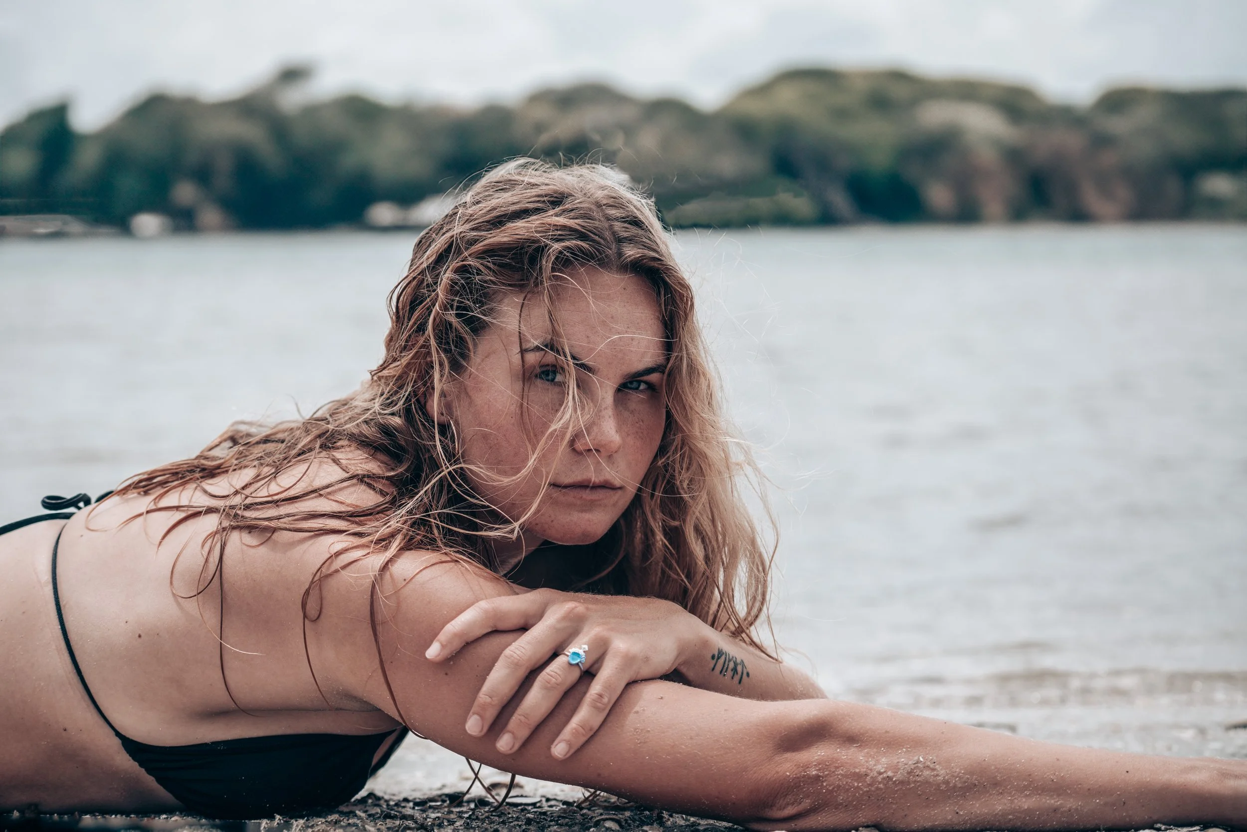 Woman wearing handcrafted ocean-inspired jewelry while relaxing by the water