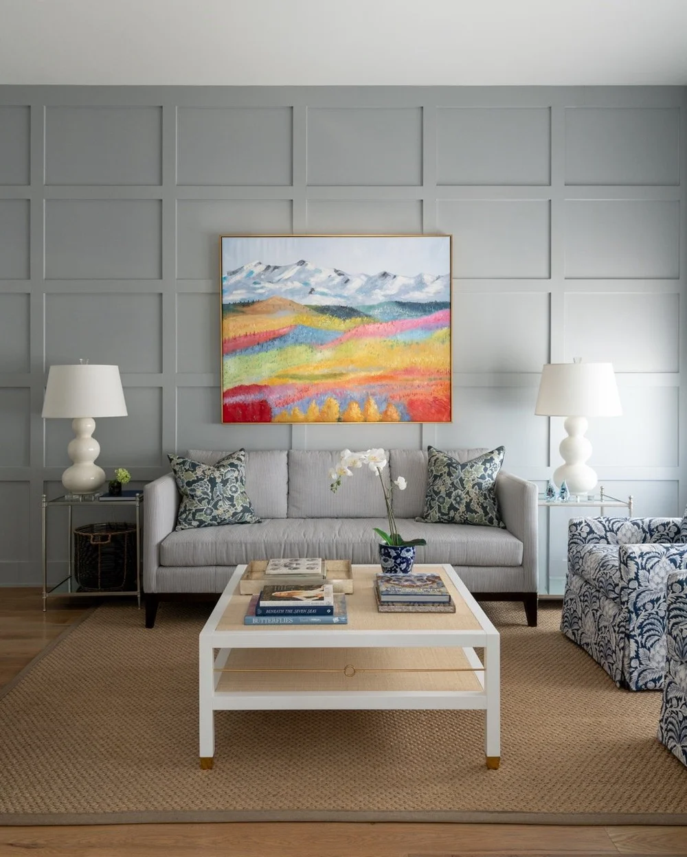 Houston living room with gray paneled walls, a colorful landscape painting, and layered interior design details