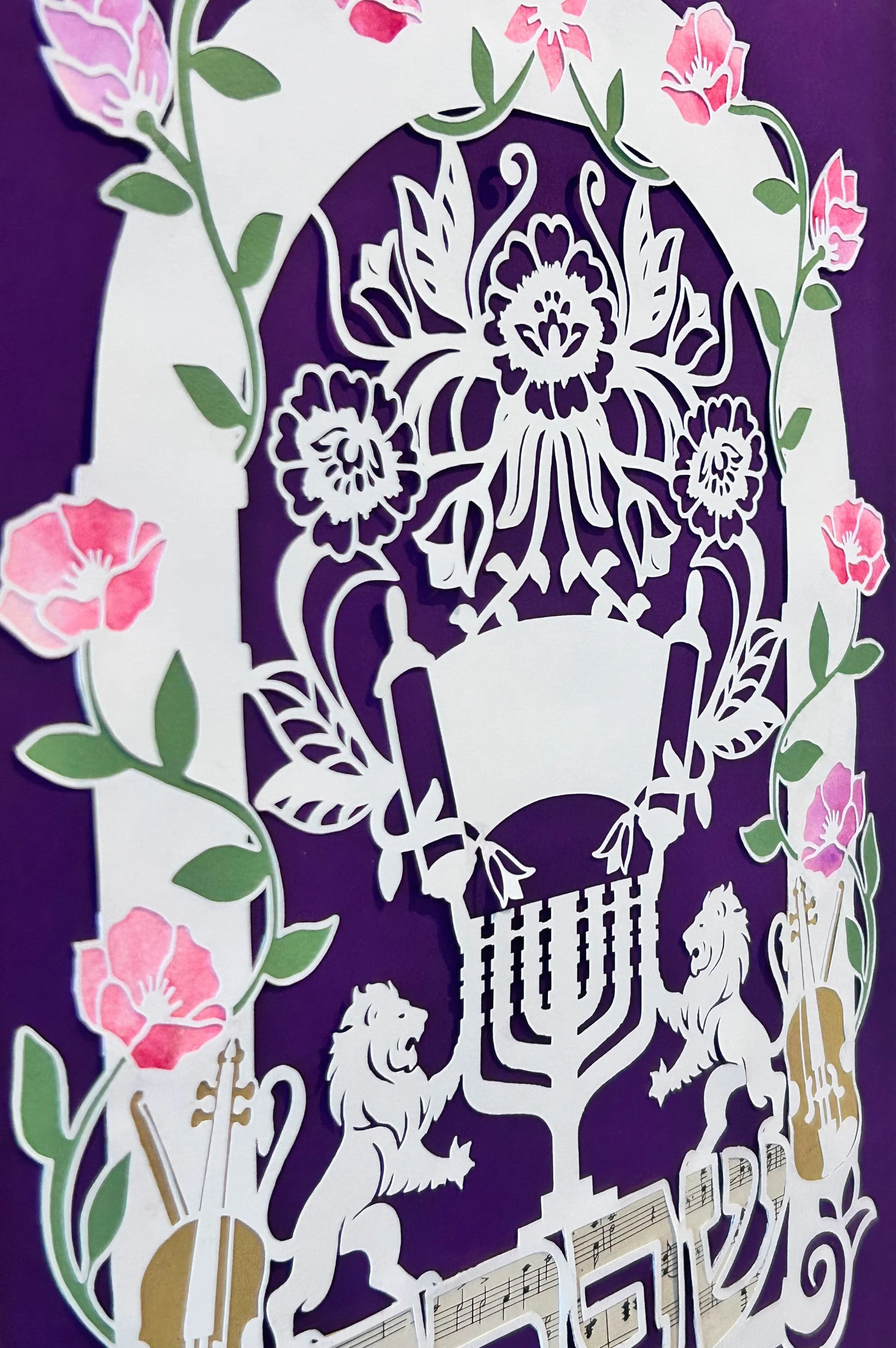 close up of custom bat mitzvah papercut artwork with Lions of Judah, torah scroll, floral elements, and Hebrew