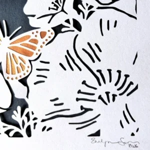 tzedek tzedek tirdof papercut close up of a large flower, gold embellished butterfly, and the artist's signature