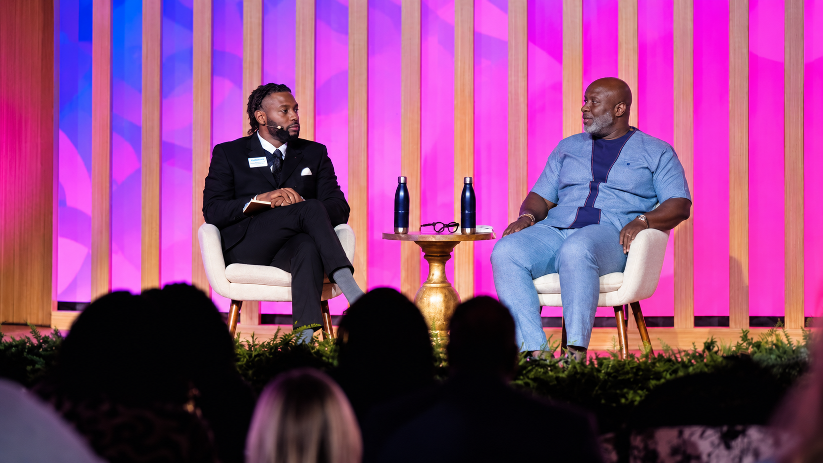 Keenan Medlock interviewing a guest onstage during a live event.