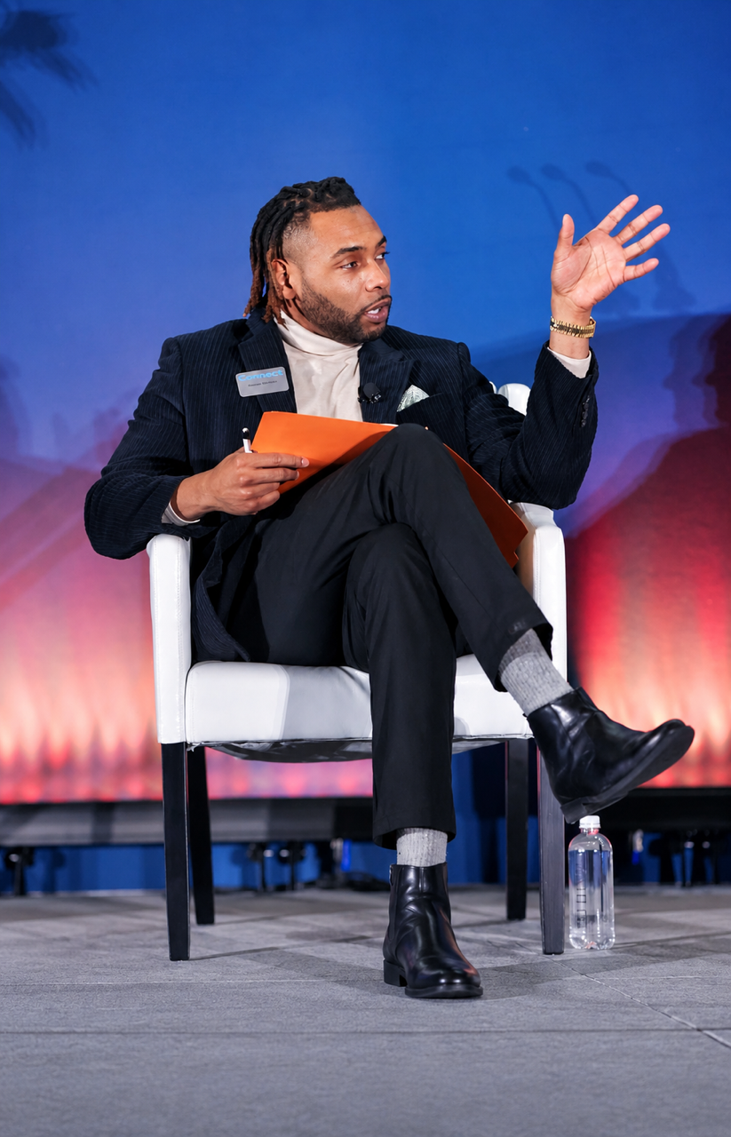 Keenan Medlock speaking onstage during a live panel conversation.