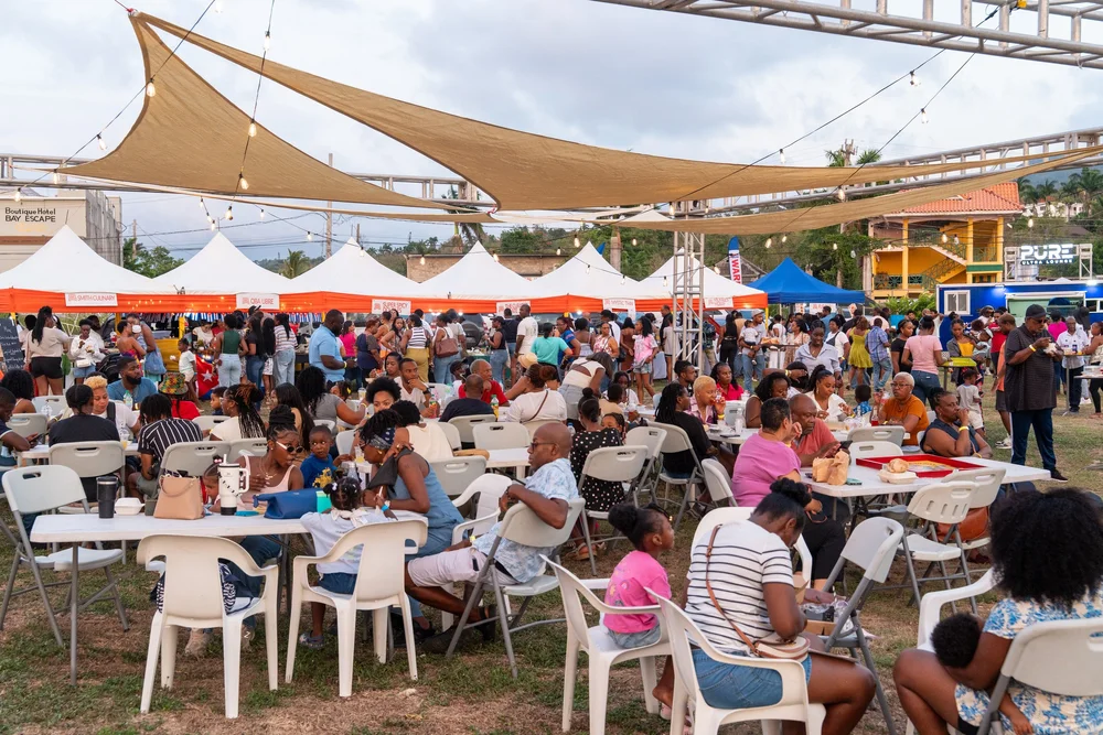 A full crowd seated under shade sails at Food and Company