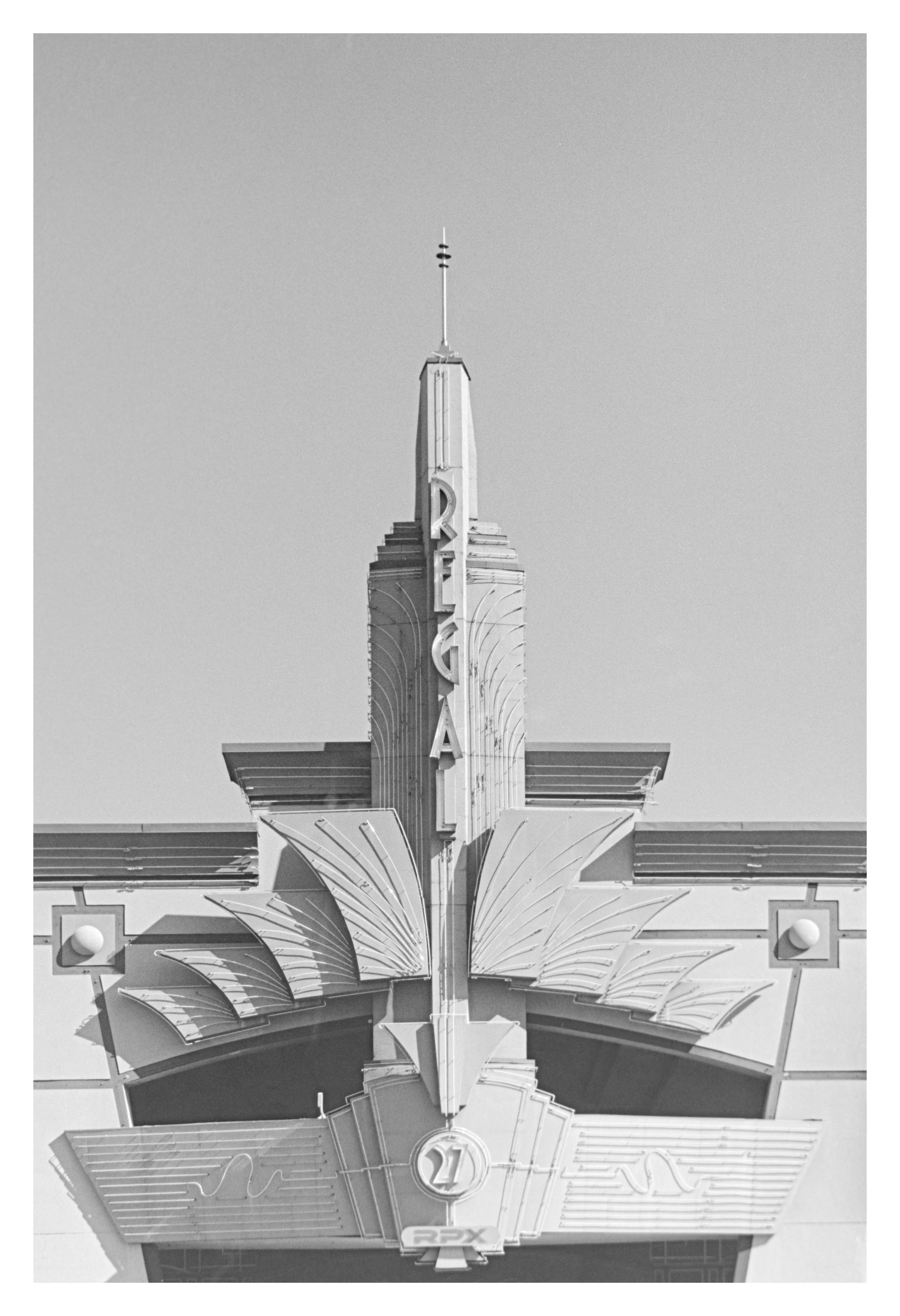 A vintage theater marquee displaying the numbers '21' with decorative Art Deco elements, including stylized leaf motifs and geometric patterns, in black and white.