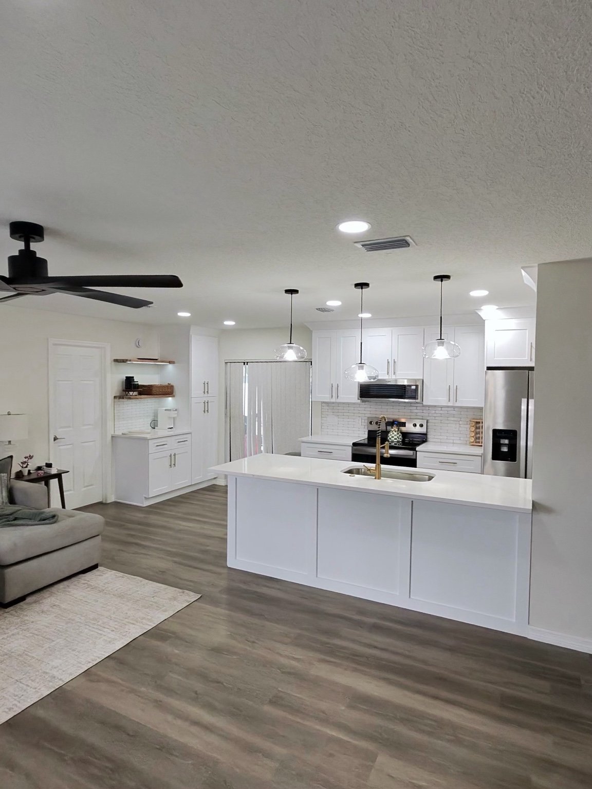 White kitchen cabinetry and a large island with gold hardware