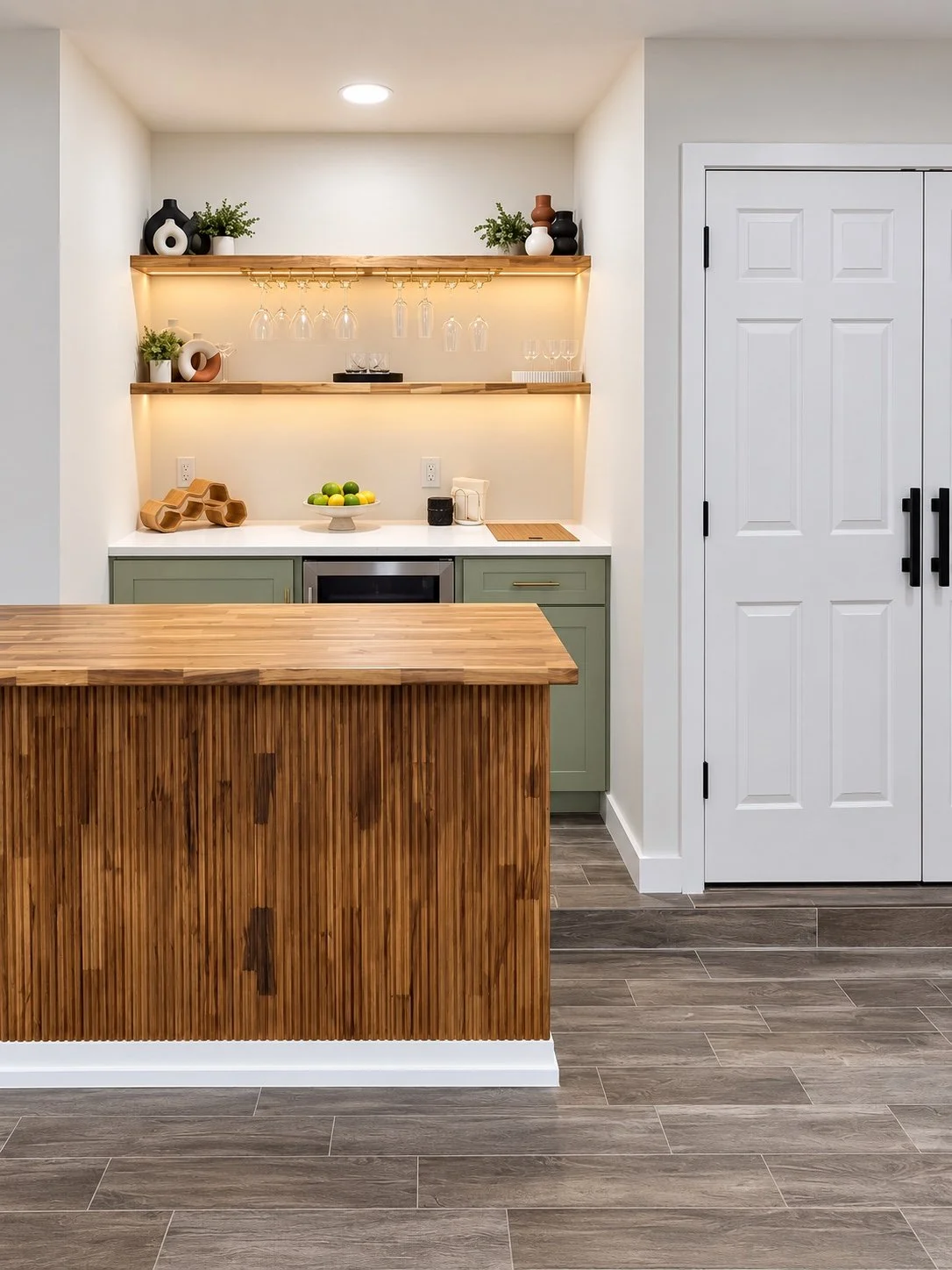 Custom home bar with a wood slat island and coordinating sage cabinetry.