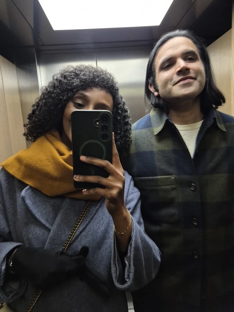 A woman taking a selfie with a man in an elevator.