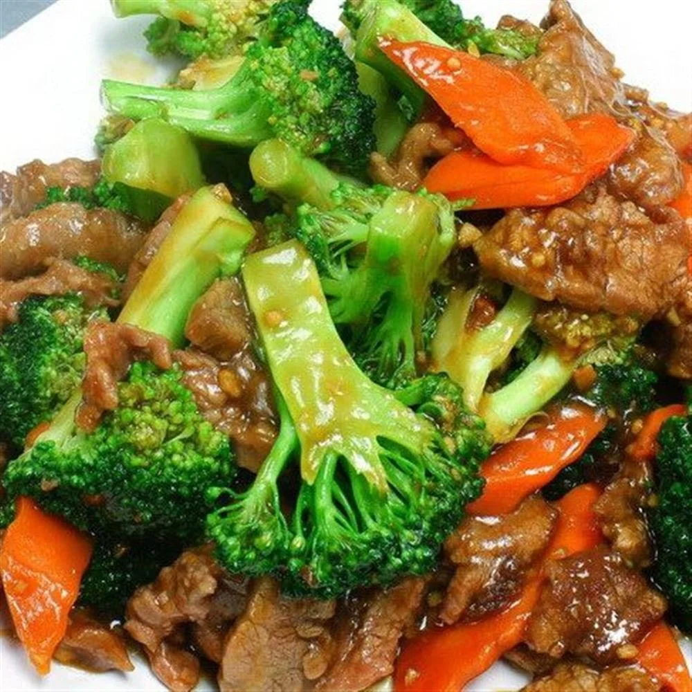 Close-up of stir-fried vegetables and beef, including broccoli, carrots, and green beans
