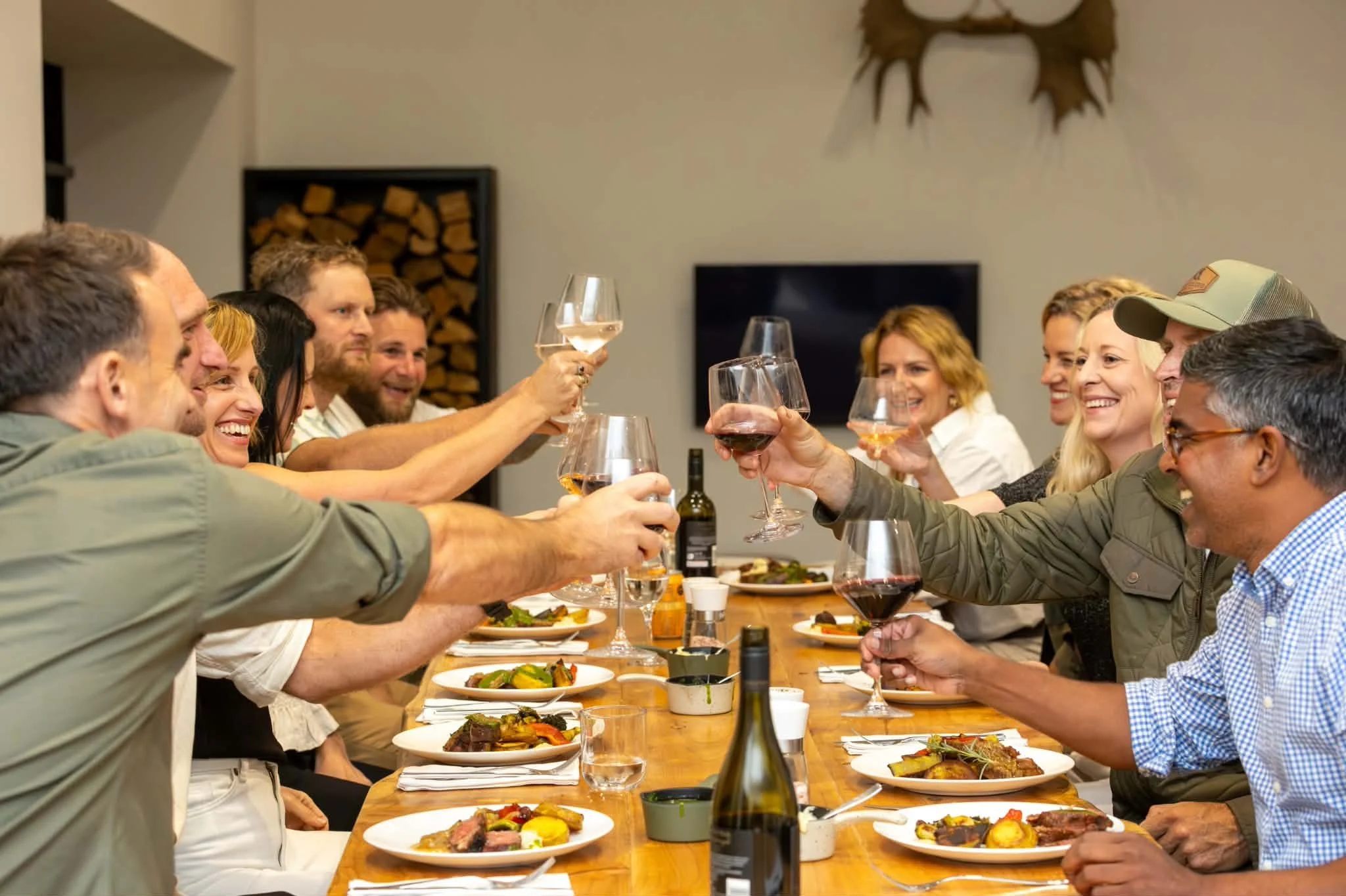 Group of friends toasting with wine glasses around a dinner table