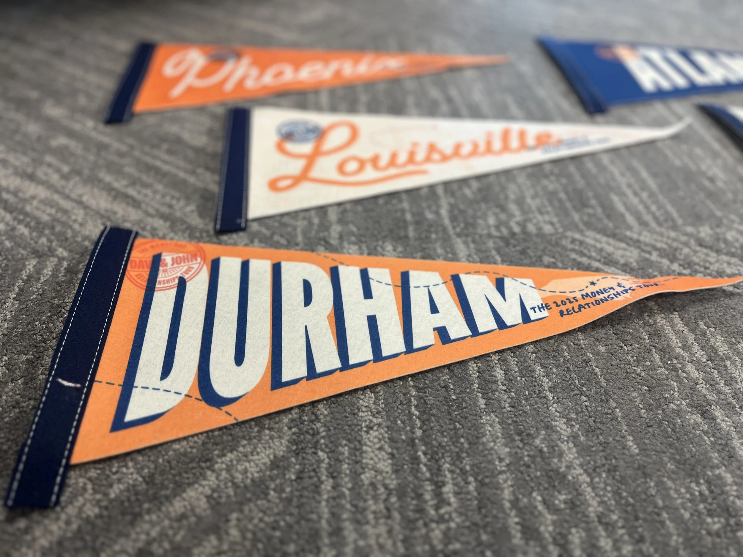 Close-up of pennants for different locations, Durham, Louisville, and Phoenix.