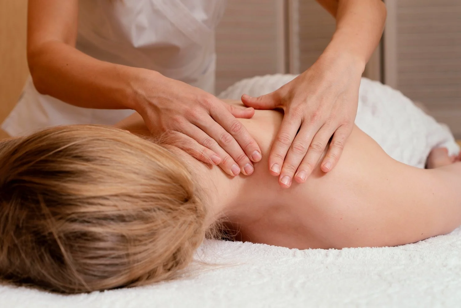 A person receiving a massage on their back in a spa or massage therapy setting.