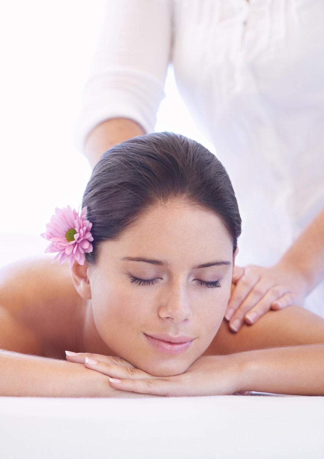 Woman receiving a massage with a flower in her hair