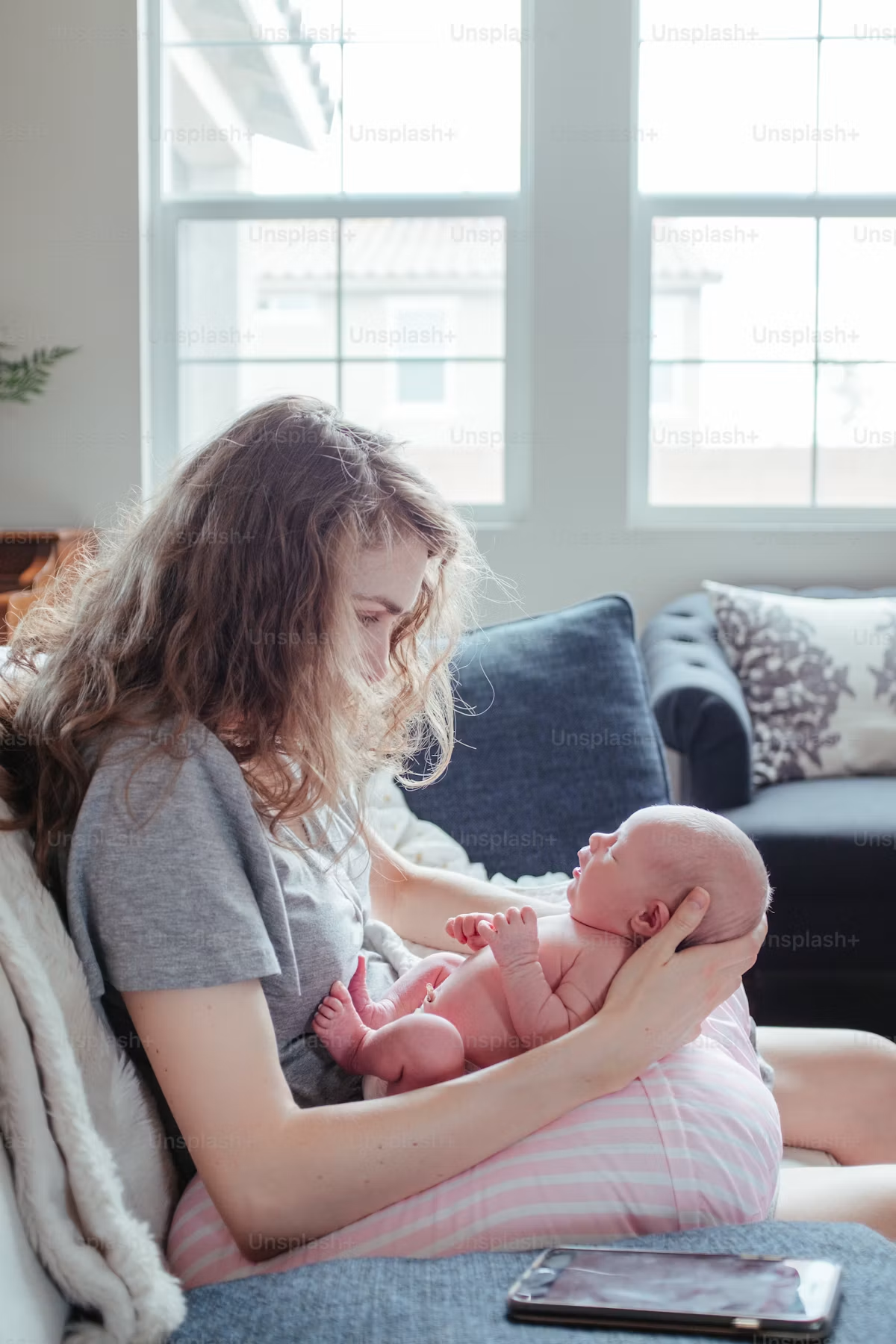 Woman sitting on couch cradling an infant