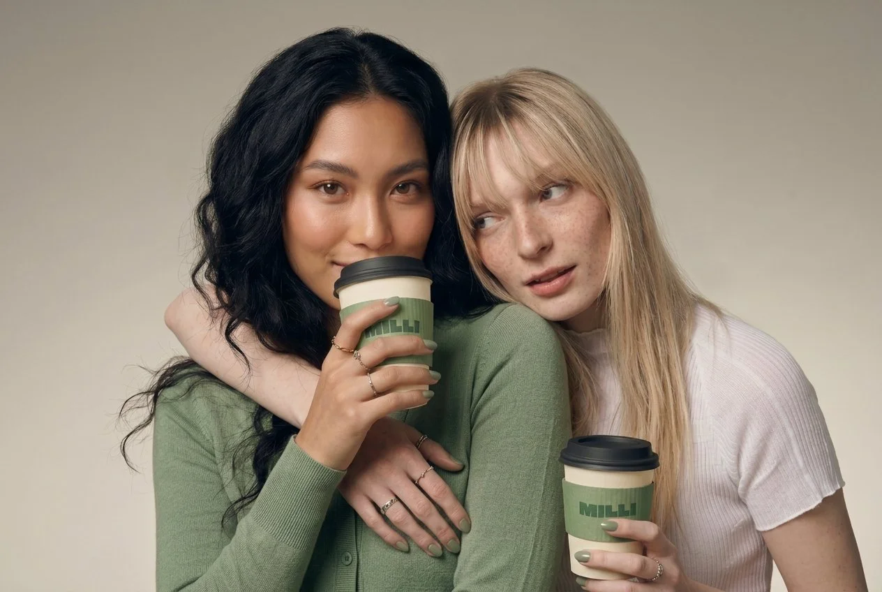 Two friends holding Milli cups, sharing a quiet moment together.