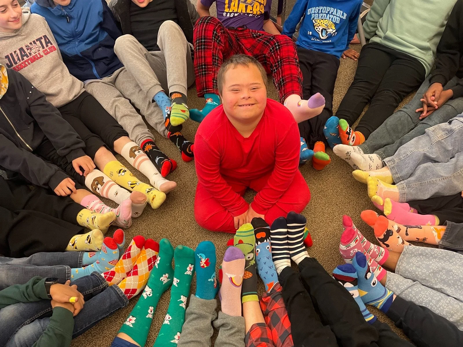 A circle of volunteers holding up socks they collected