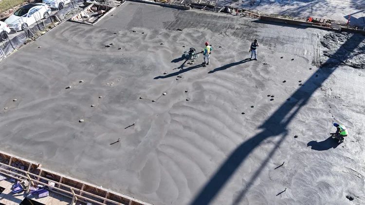 Bishop Modern crews finishing a broad concrete deck, photographed from above