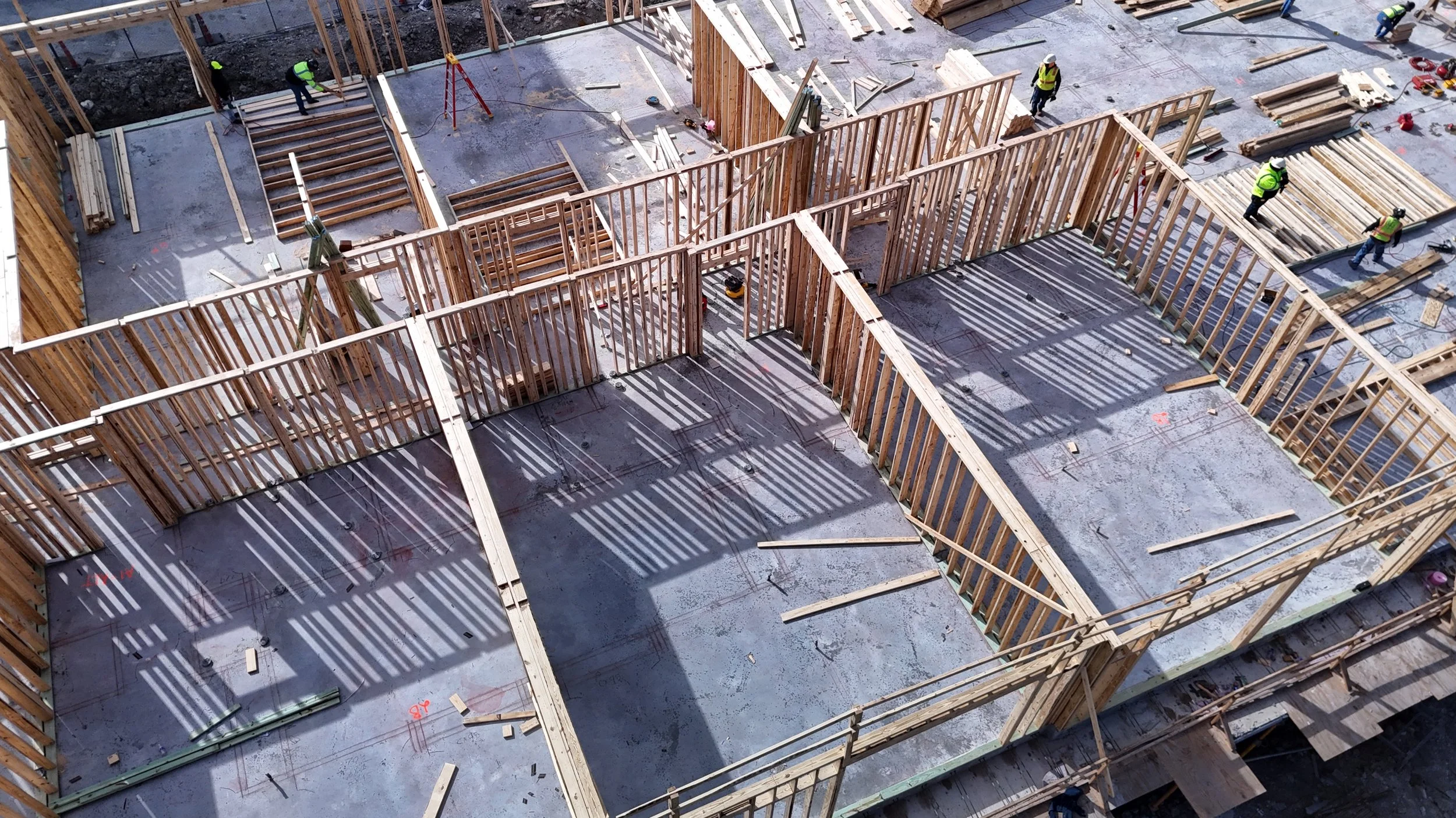 Aerial view of wood framing above a concrete slab at a construction site