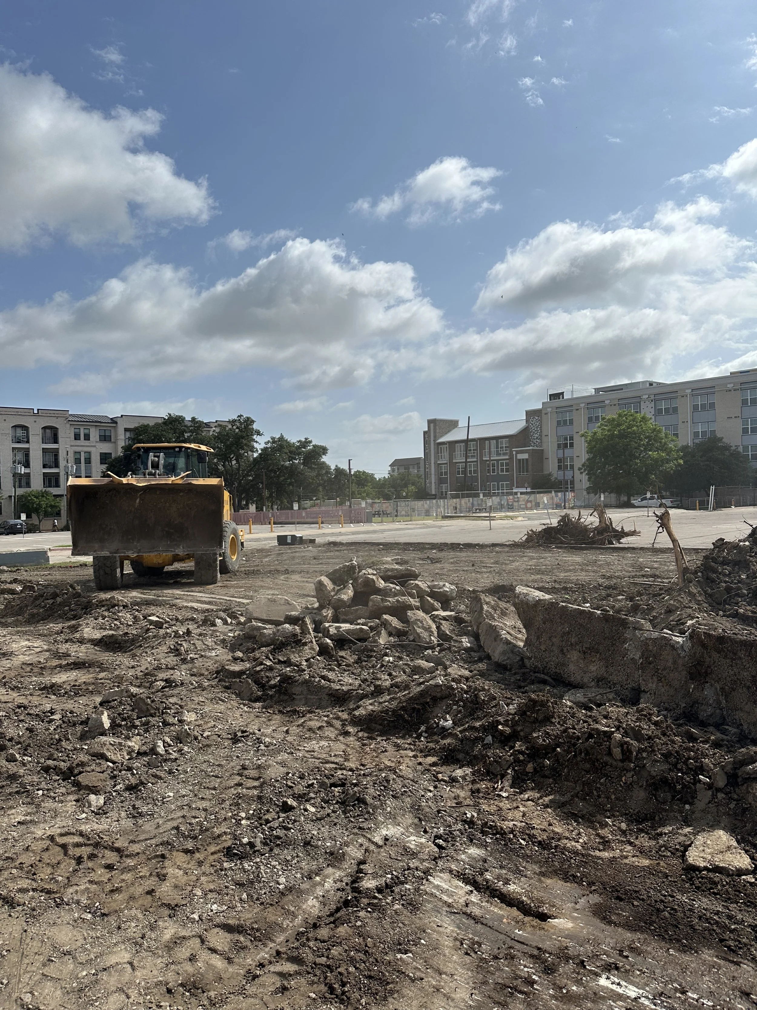 Construction truck and broken pavement during parking lot demolition.
