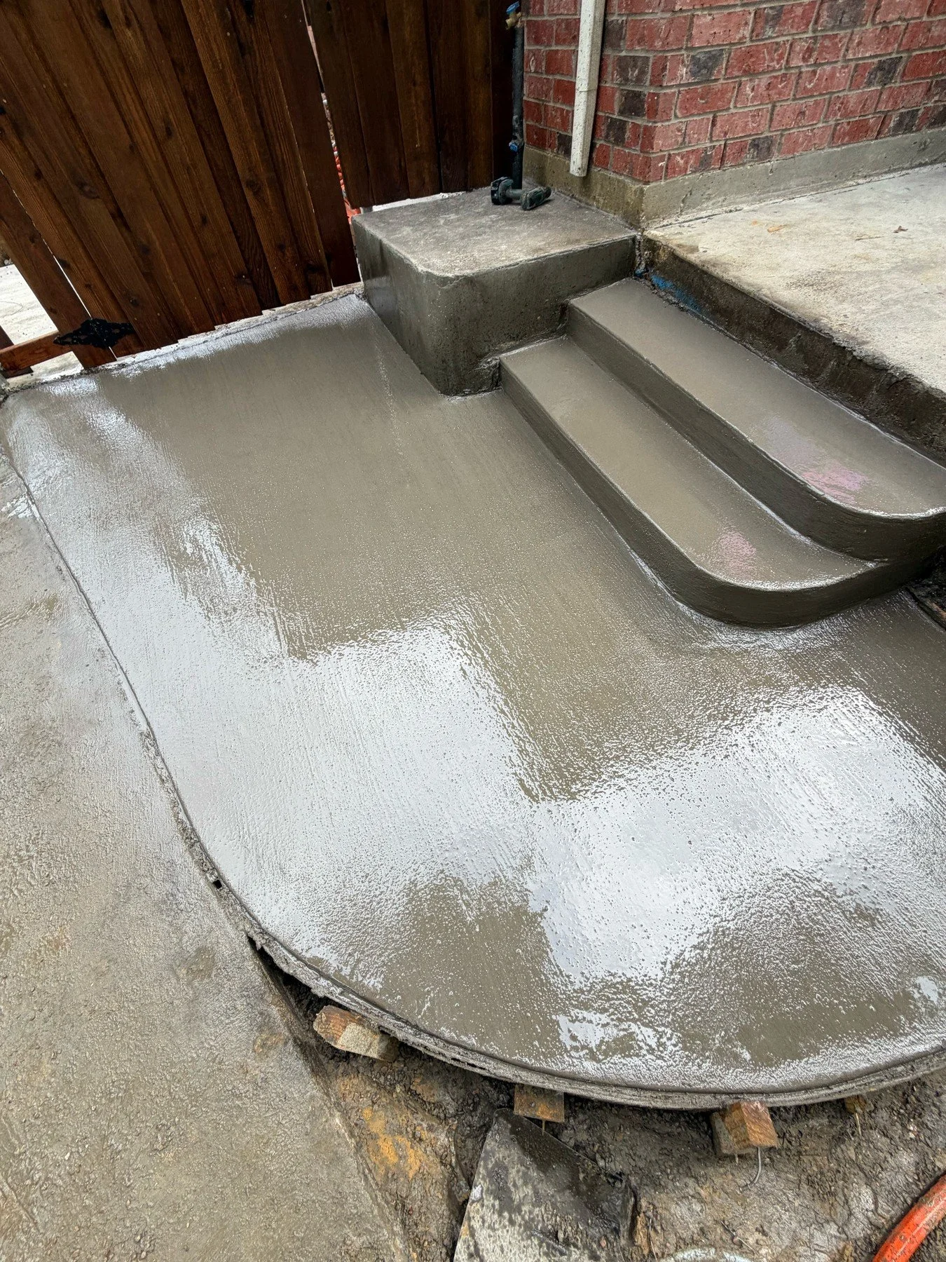 Freshly finished concrete steps meet a curved residential landing.