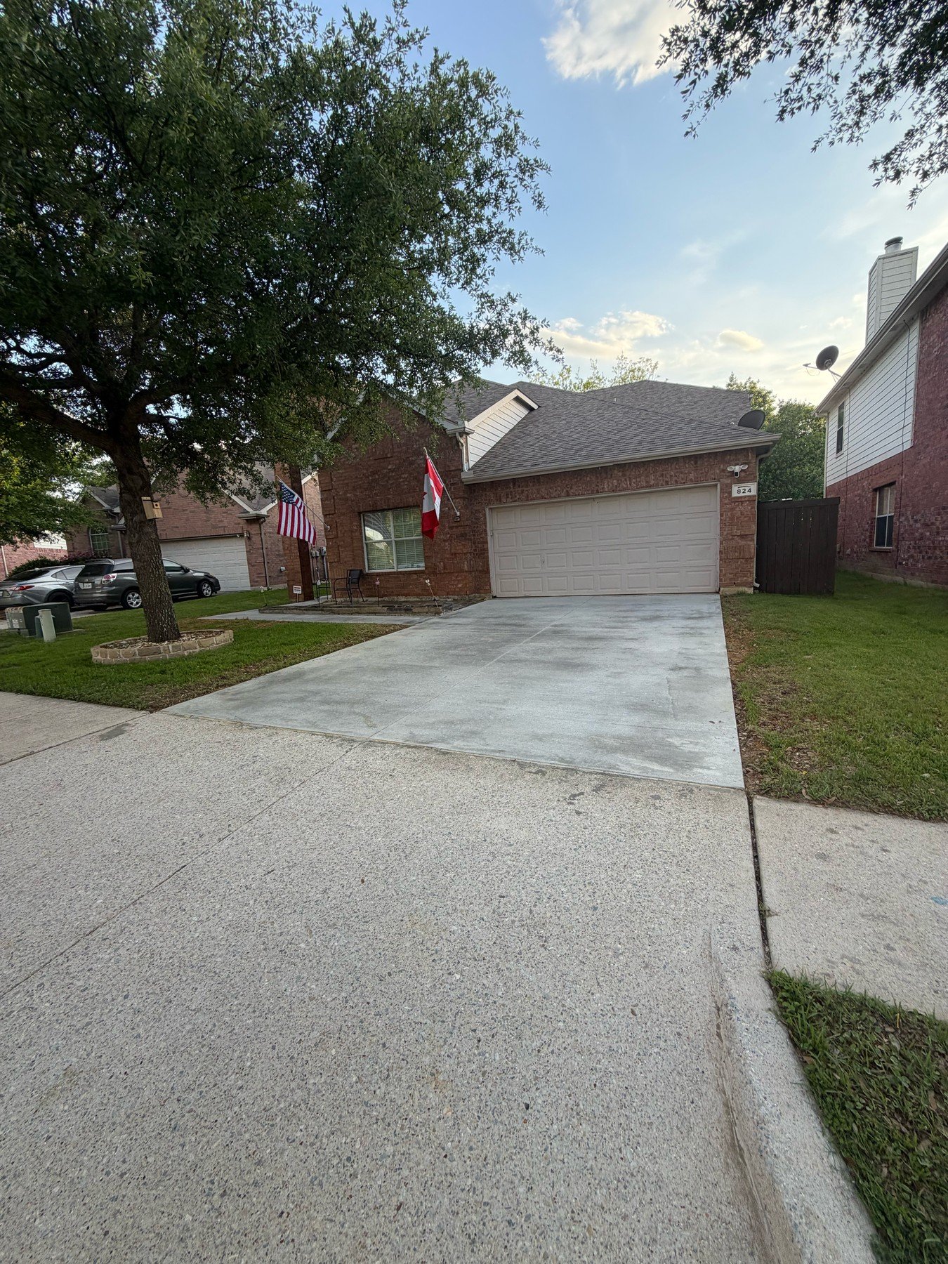 Completed concrete driveway at a brick home.
