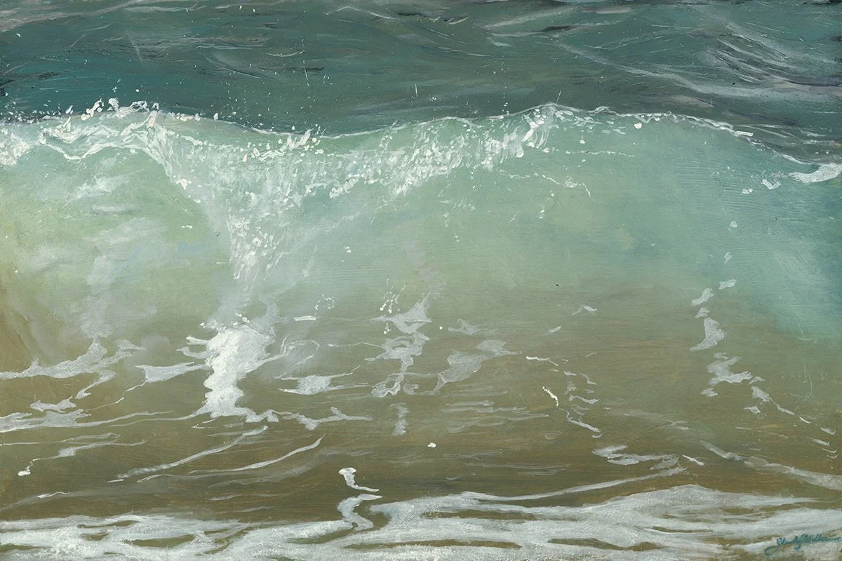Waves crashing onto a beach with white foam, clear turquoise water, and sandy shore.