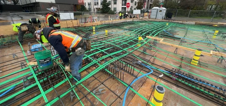 Crews working around reinforcement and service routes at the Bishop Modern commercial construction site.