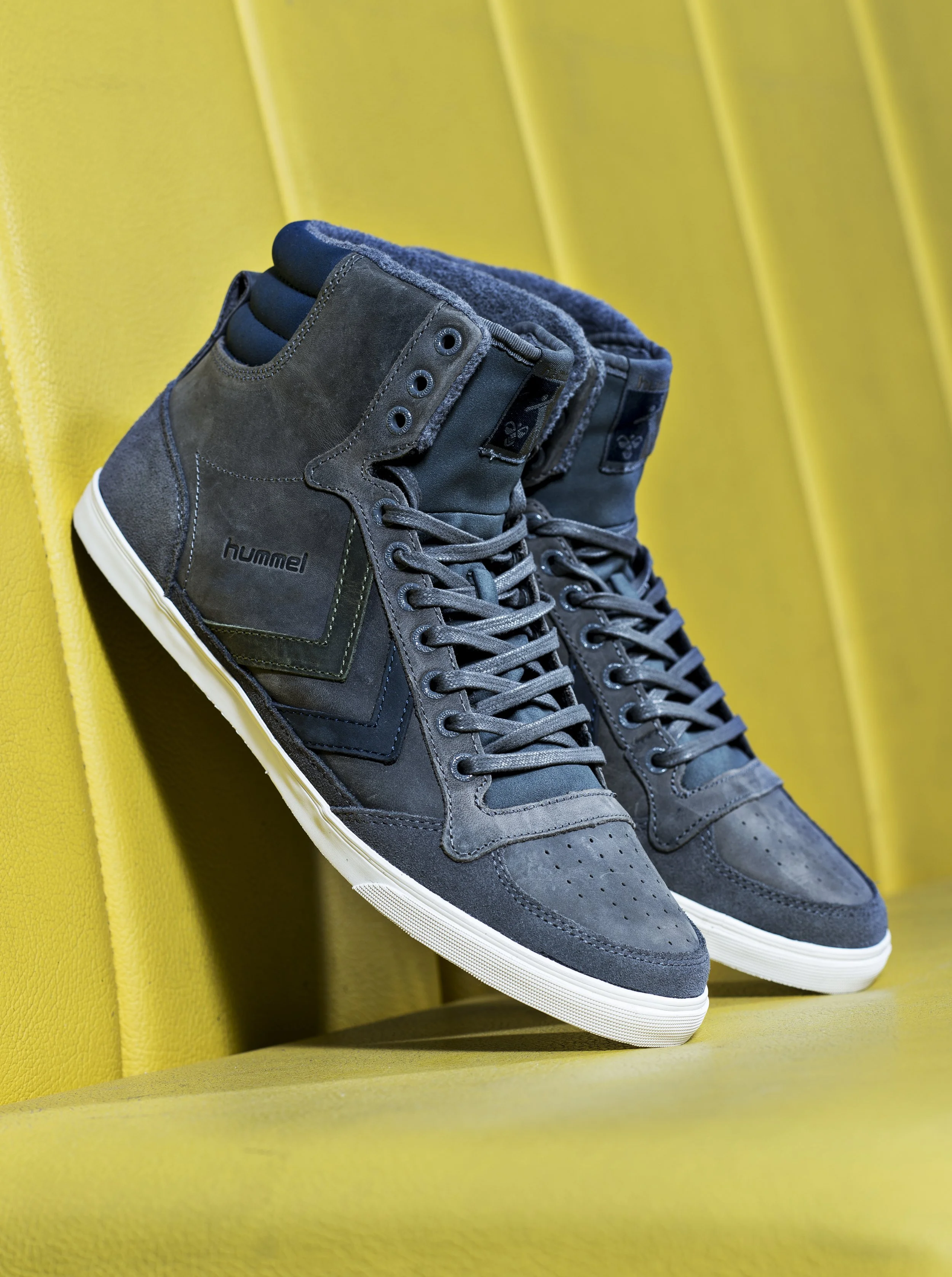Une paire de baskets grises sur un fond jaune