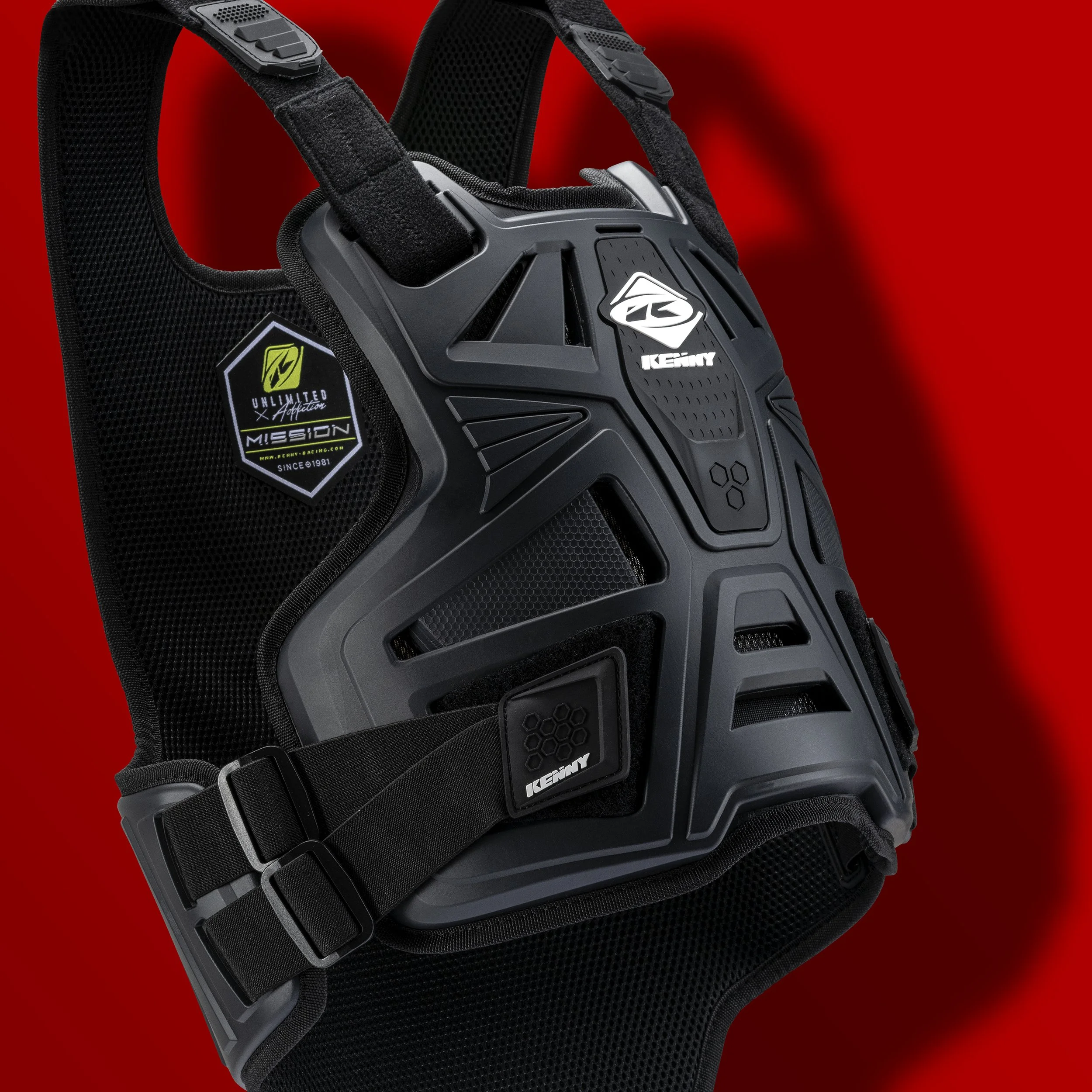 Pare-pierre, protection de motocross noir avec logo blanc, équipé pour le vélo ou motocross, contre un fond rouge.