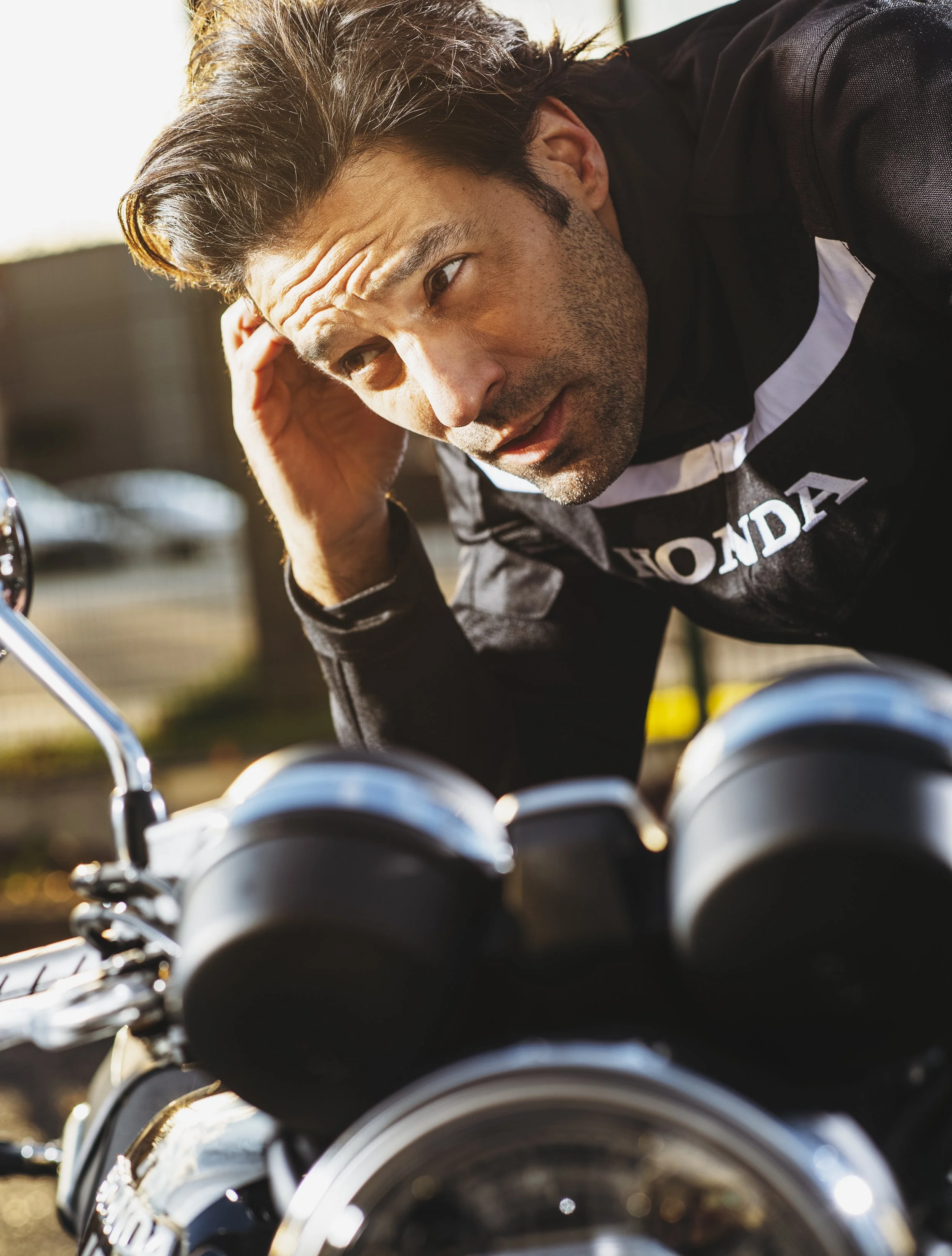 Un homme qui regarde dans une rangée de motos, en concentrant son attention sur celles devant lui.