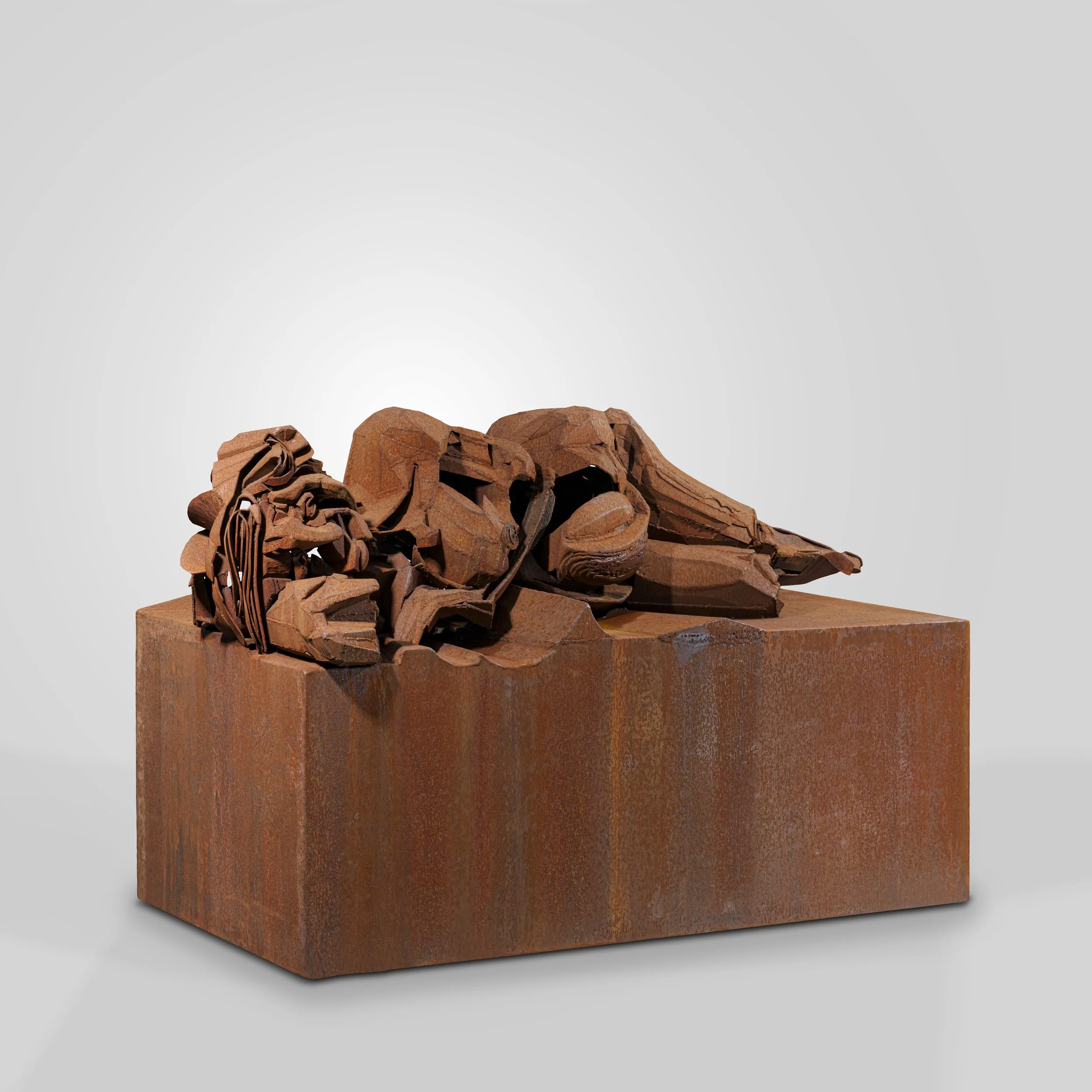 Une sculpture en acier corten représentant un lion gravée dans un bloc de bois