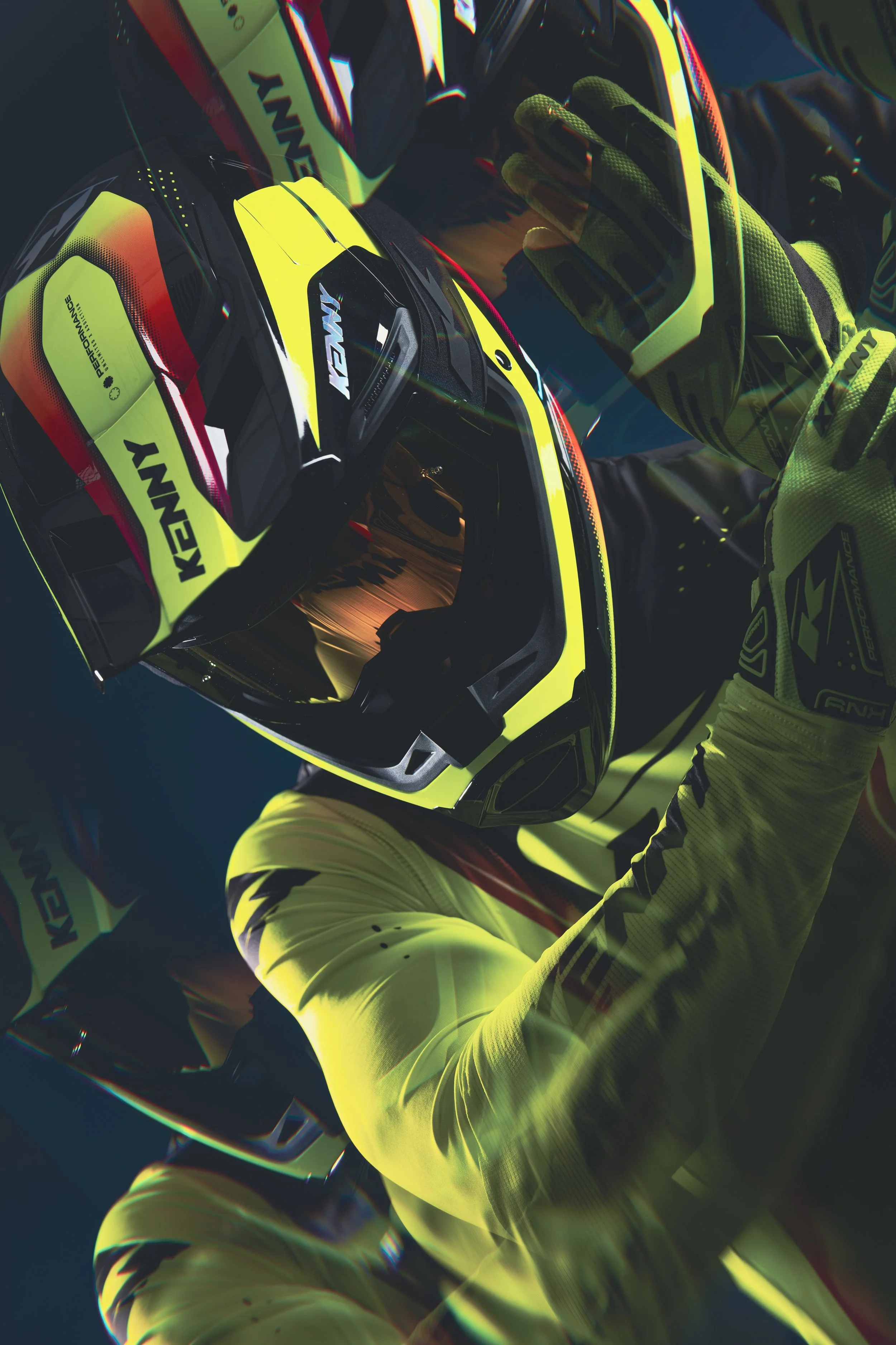 Un pilote en combinaison de moto et casque jaune vif avec des accents noirs, se préparant à une course, tenant son casque avec une main.