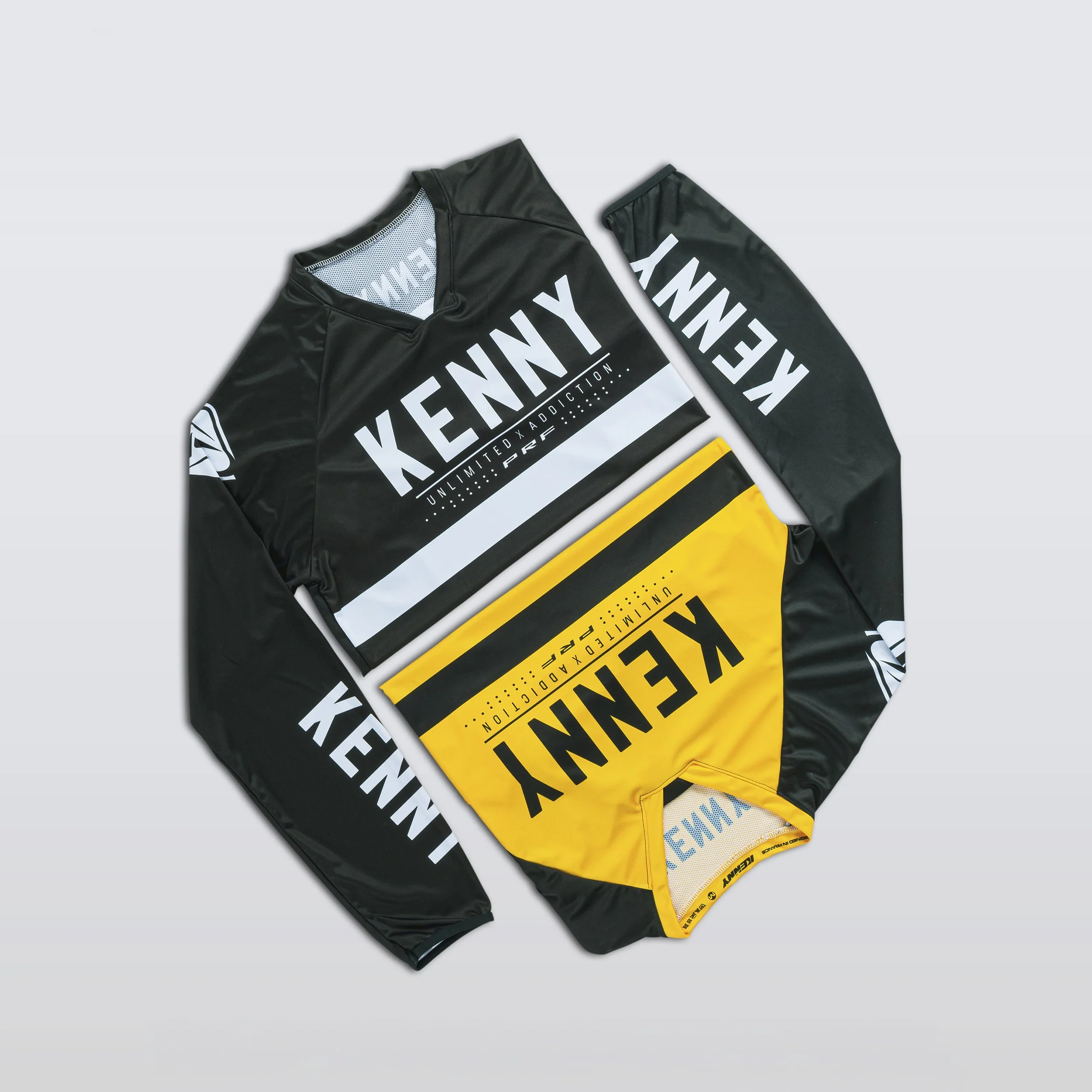 Vêtements de sport noirs avec des bandes jaunes et la mention 'KENDY' en blanc.