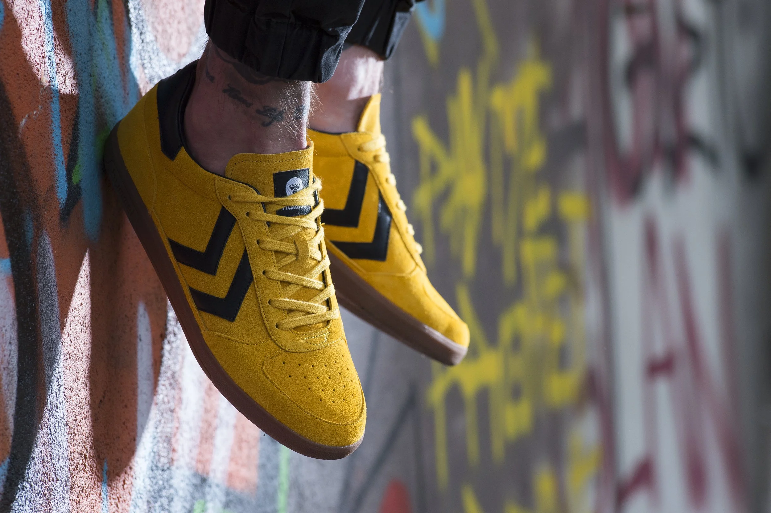 Chaussures de sport jaunes sur un sol graffité.