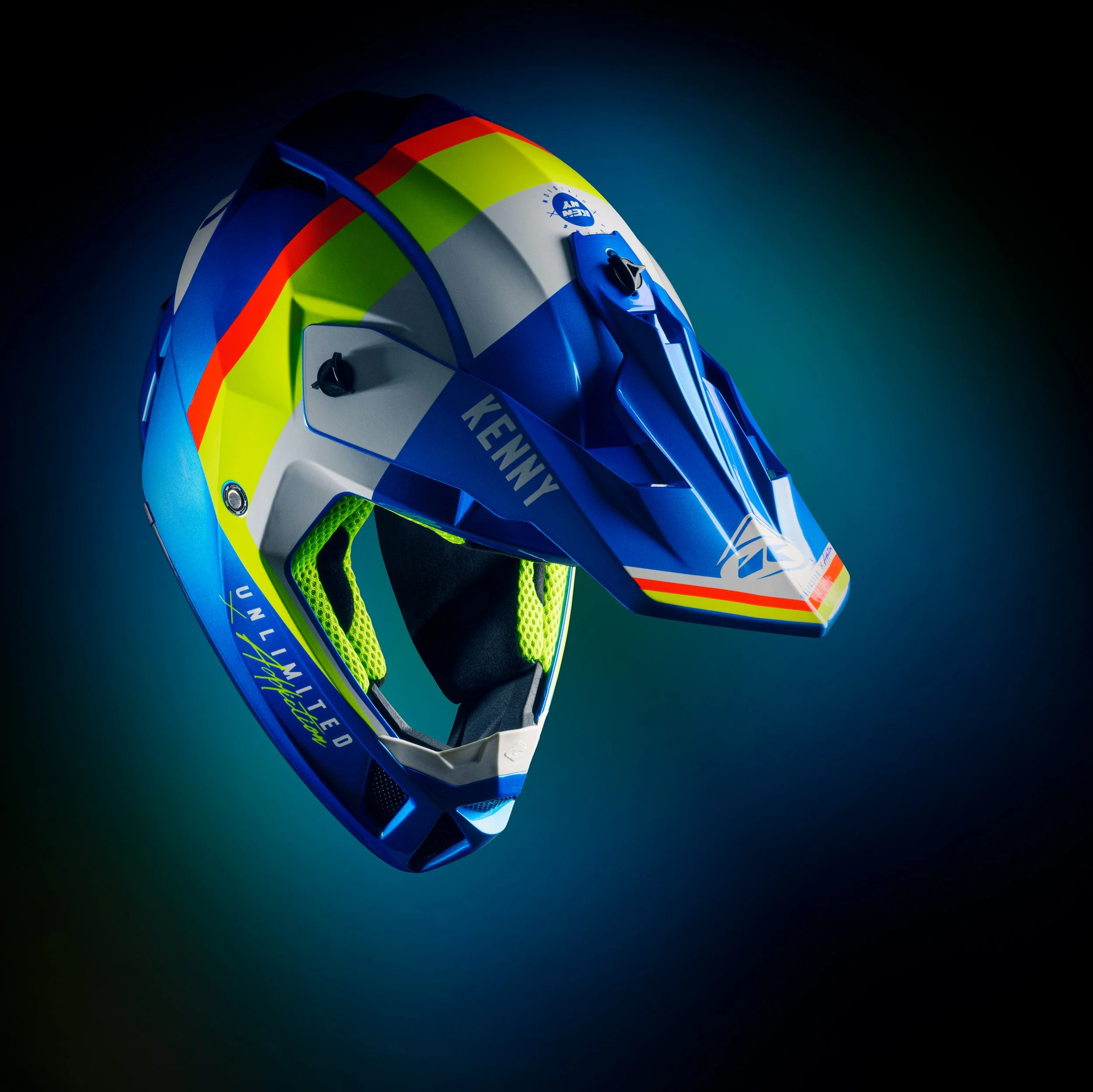 Casque de moto coloré avec des motifs bleus, jaunes, orange et verts, exposé contre un fond sombre.