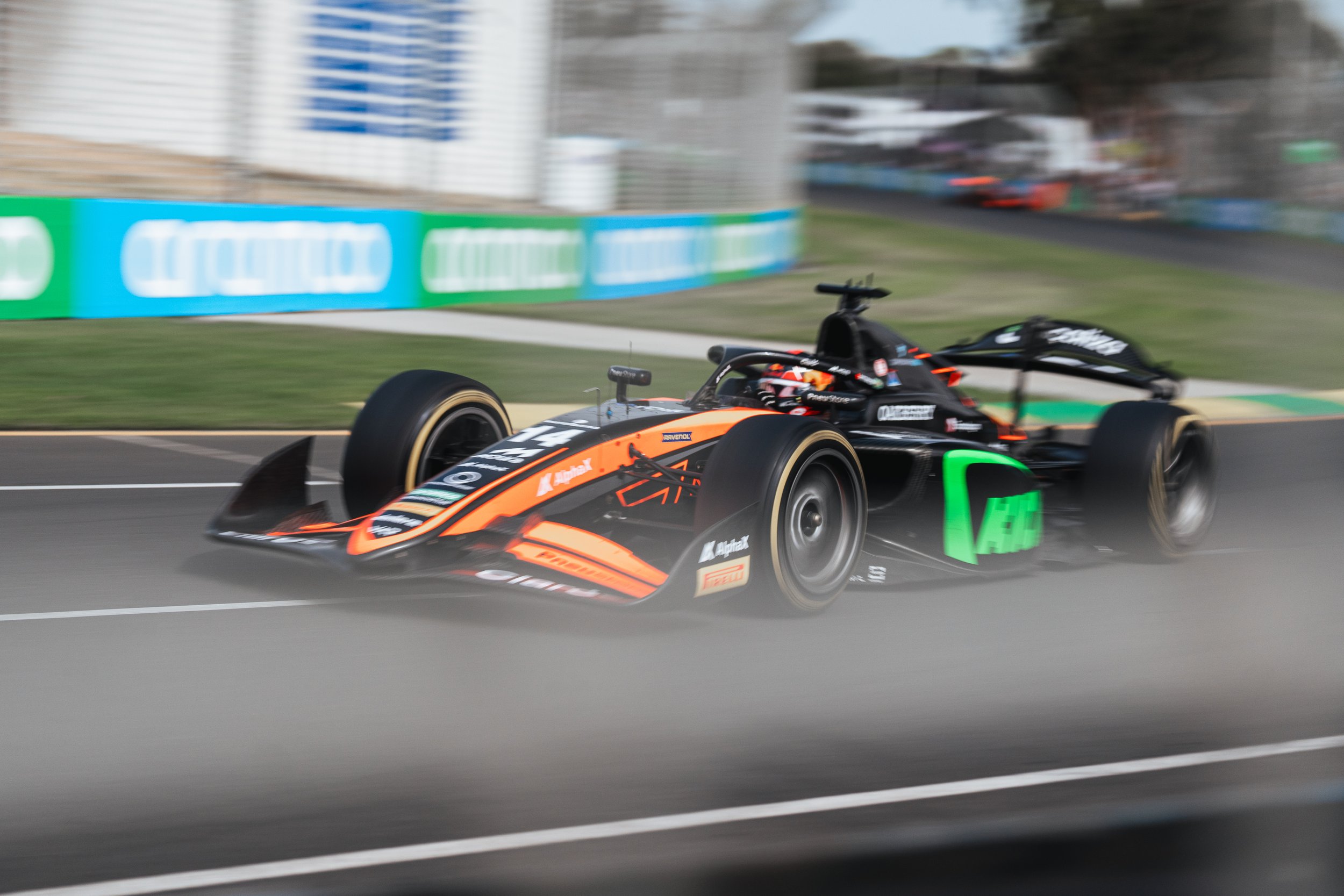 A race car moving at high speed on a race track, with motion blur in the background.
