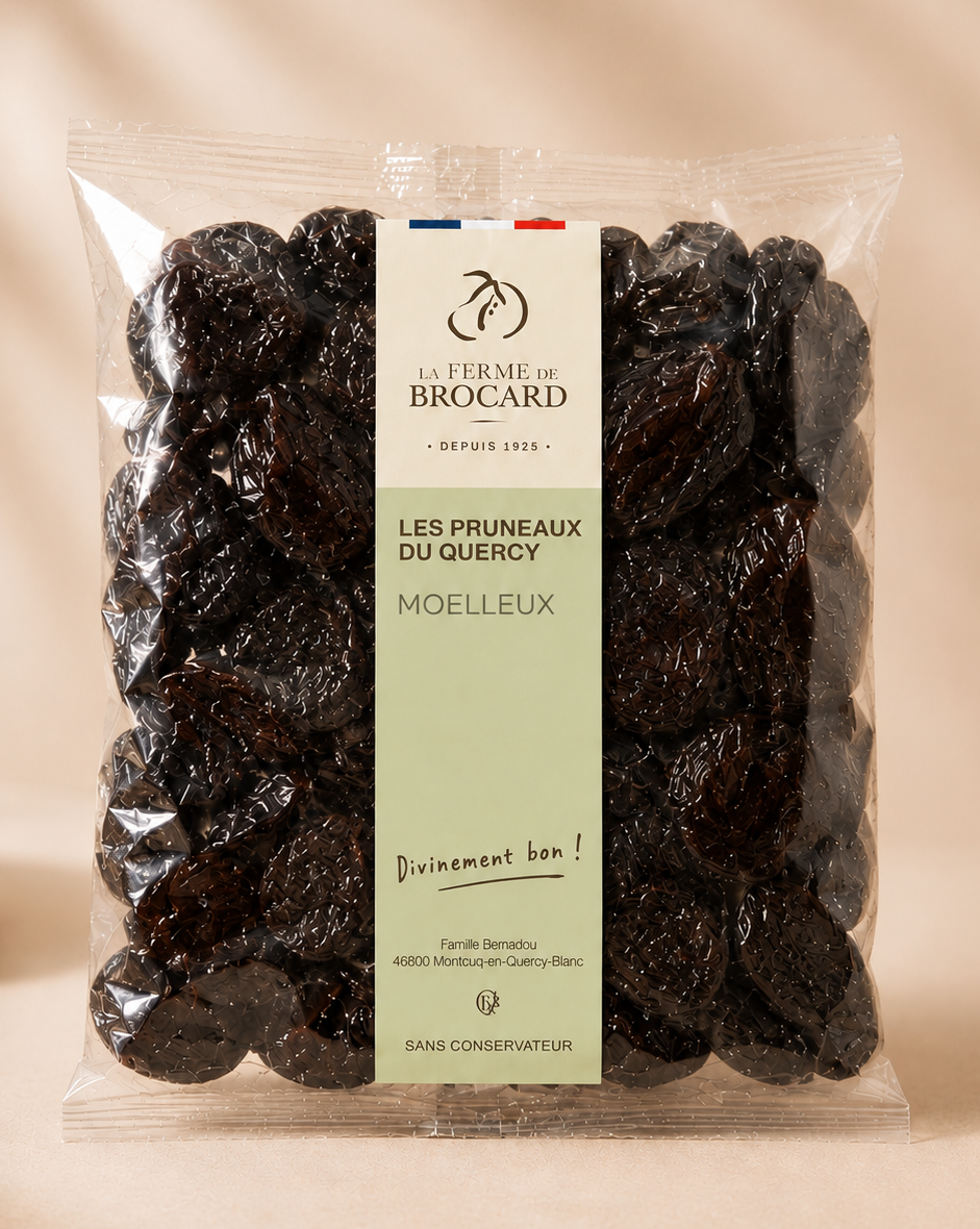 A clear plastic bag of dark dried prunes with a label from La Ferme de Brocard, featuring French text and a logo of a cherry, indicating the product is organic and preservative-free.