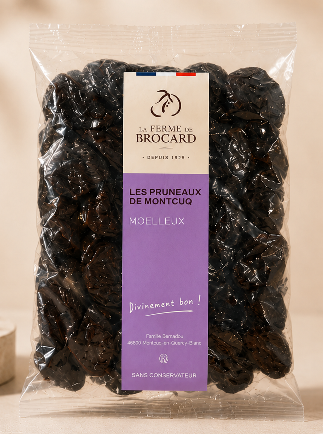 A clear plastic bag of dark pruneau de Montcuq prunes with a label displaying the brand 'La Ferme de Brocard', written in French.
