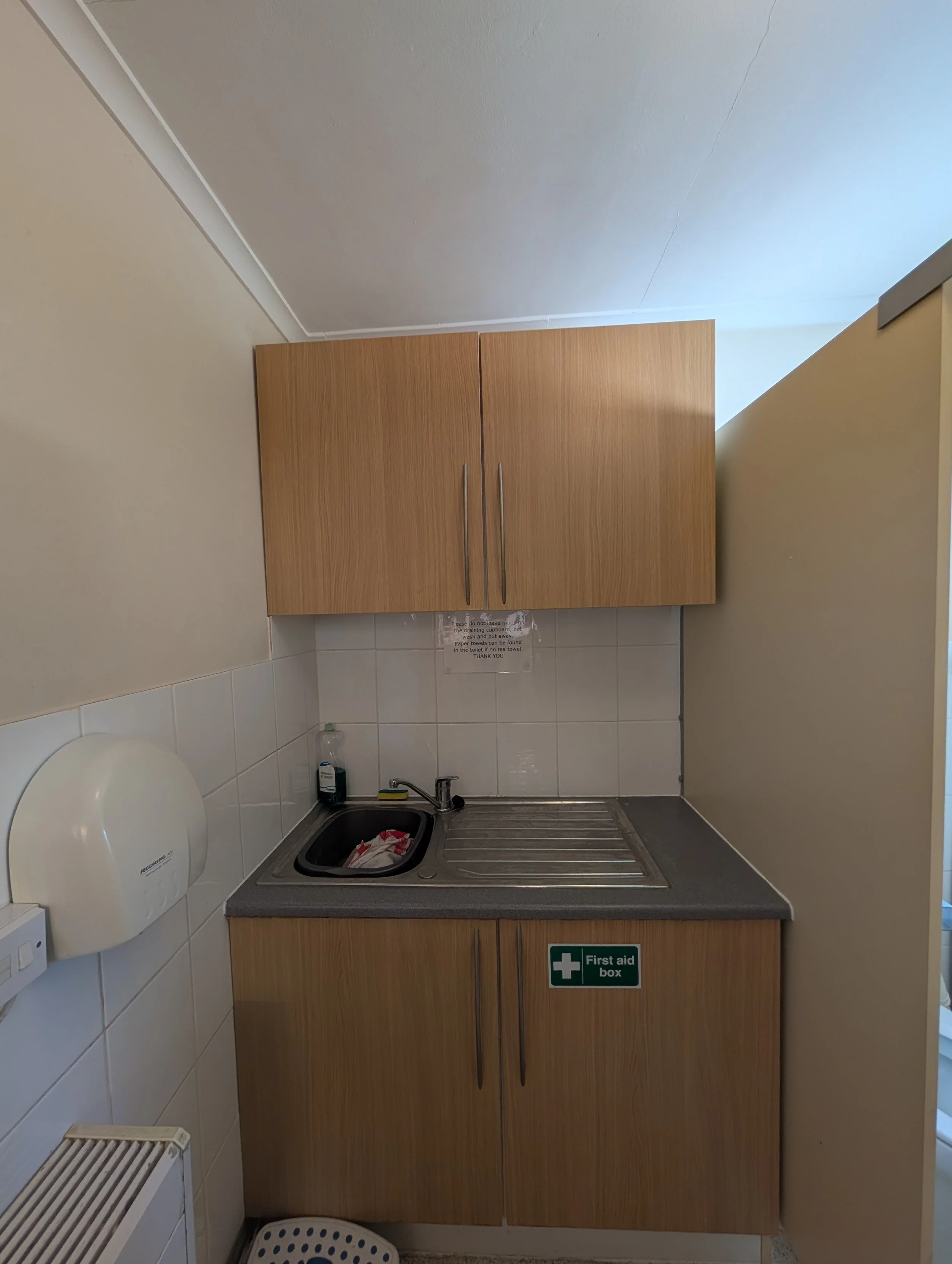 Small hall kitchenette with adjacent single toilet 