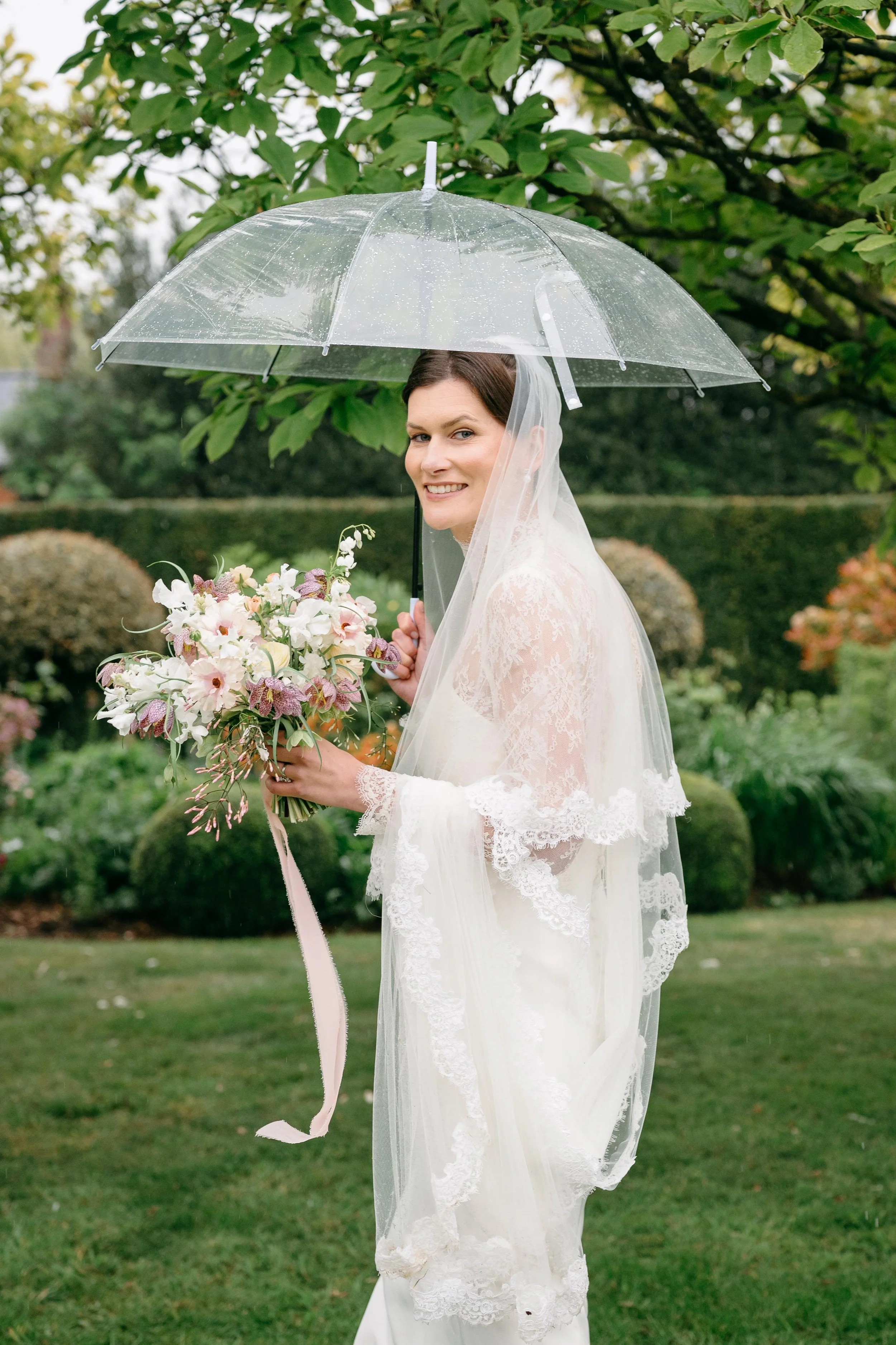 bride holding umbrella with pretty flowers