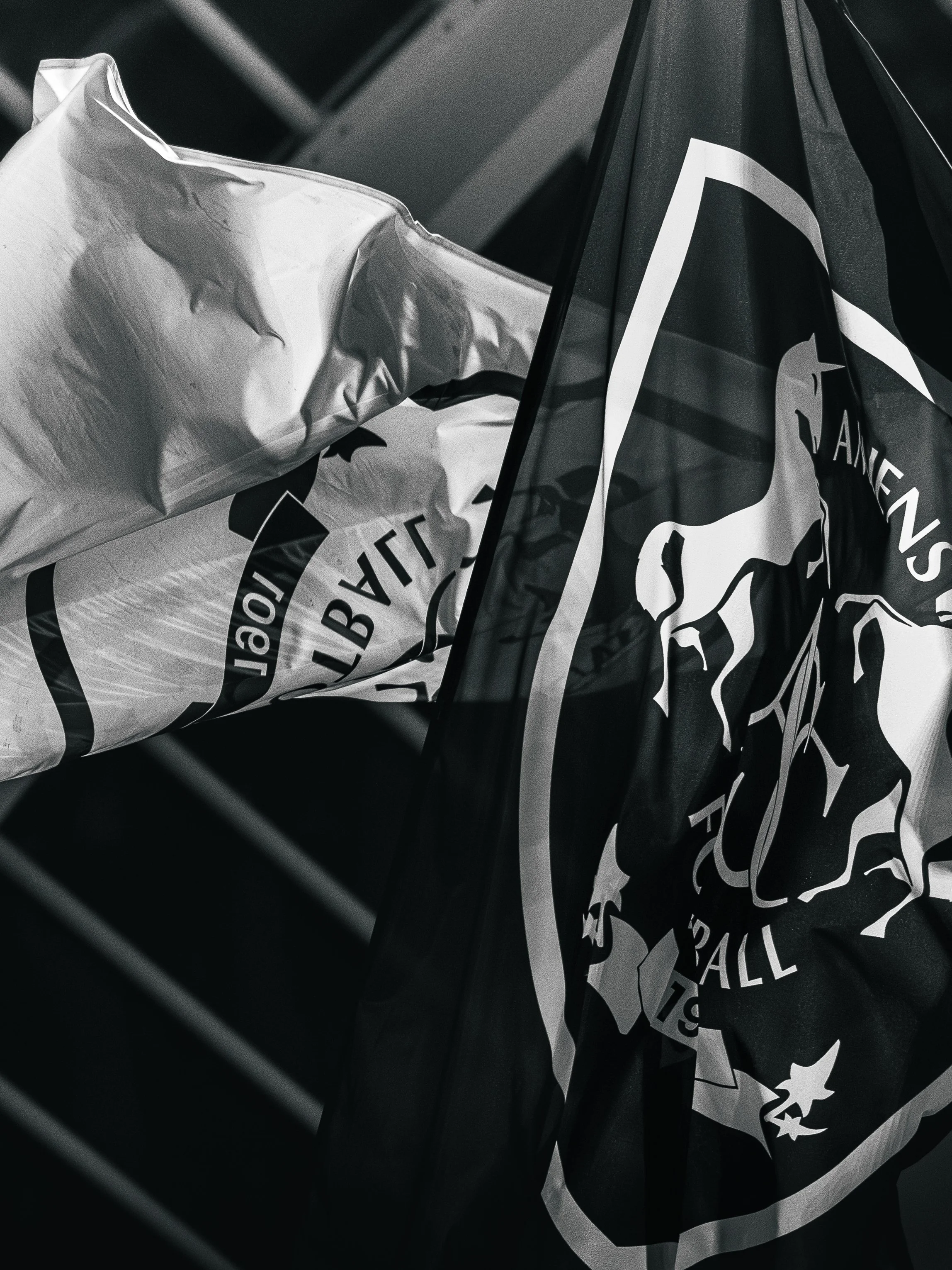 Une voiture avec un drapeau noir et blanc, probablement lié à une équipe de football ou un club, accroché à la voiture.