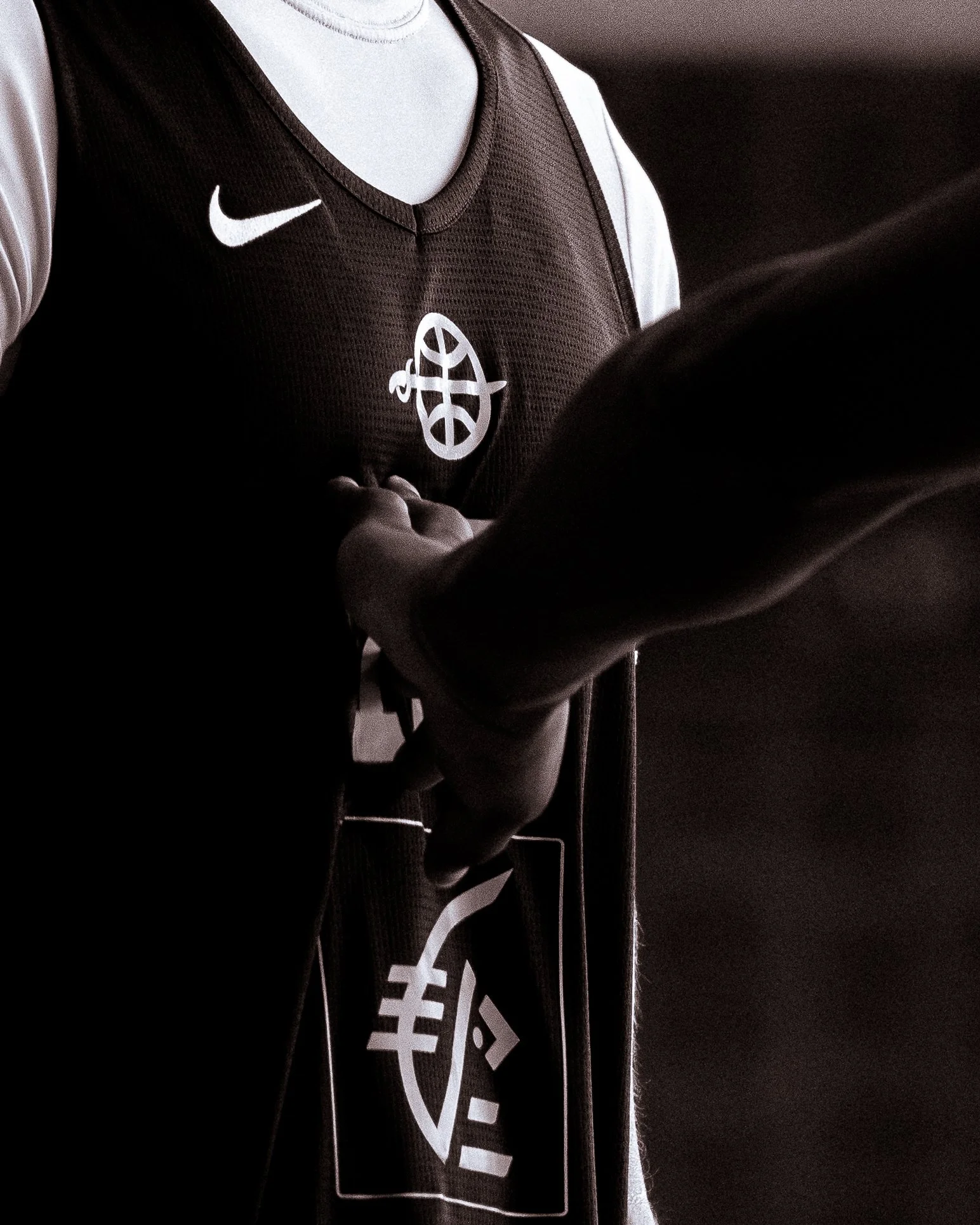 Vêtements de sport noirs et blancs avec logo Nike et un symbole affiché en blanc.