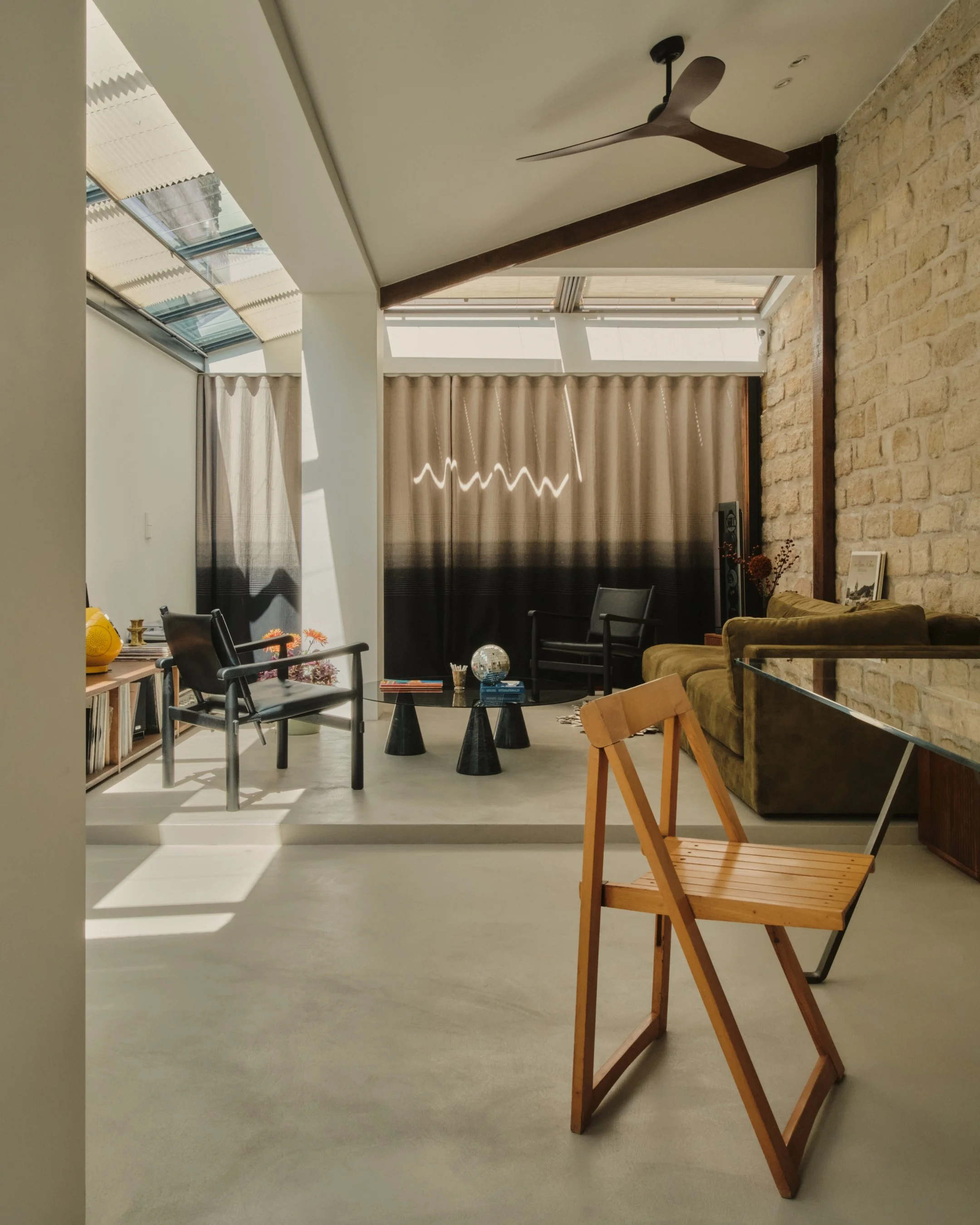 Mélange de décoration vintage et chinées à du contemporain. Lumière naturelle sous la verrière. Fauteuil Perriand. Canapé Panac. Lepic à Montmartre, projet MABE architecte d'intérieur Paris 