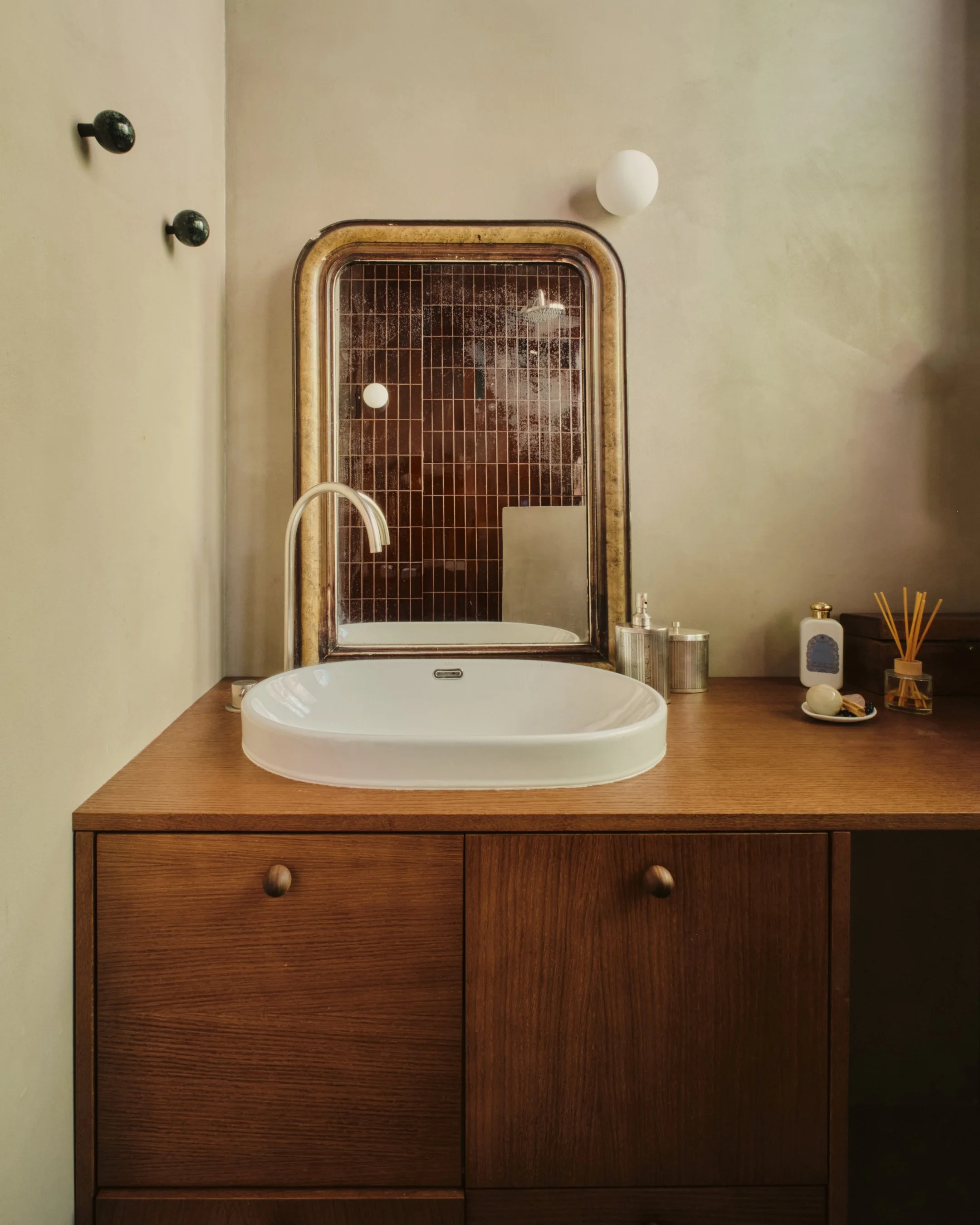 Salle de bain midcentury. Bois foncé, détails de poignées en chêne et miroir chiné. Lepic à Montmartre, projet MABE architecte d'intérieur Paris 