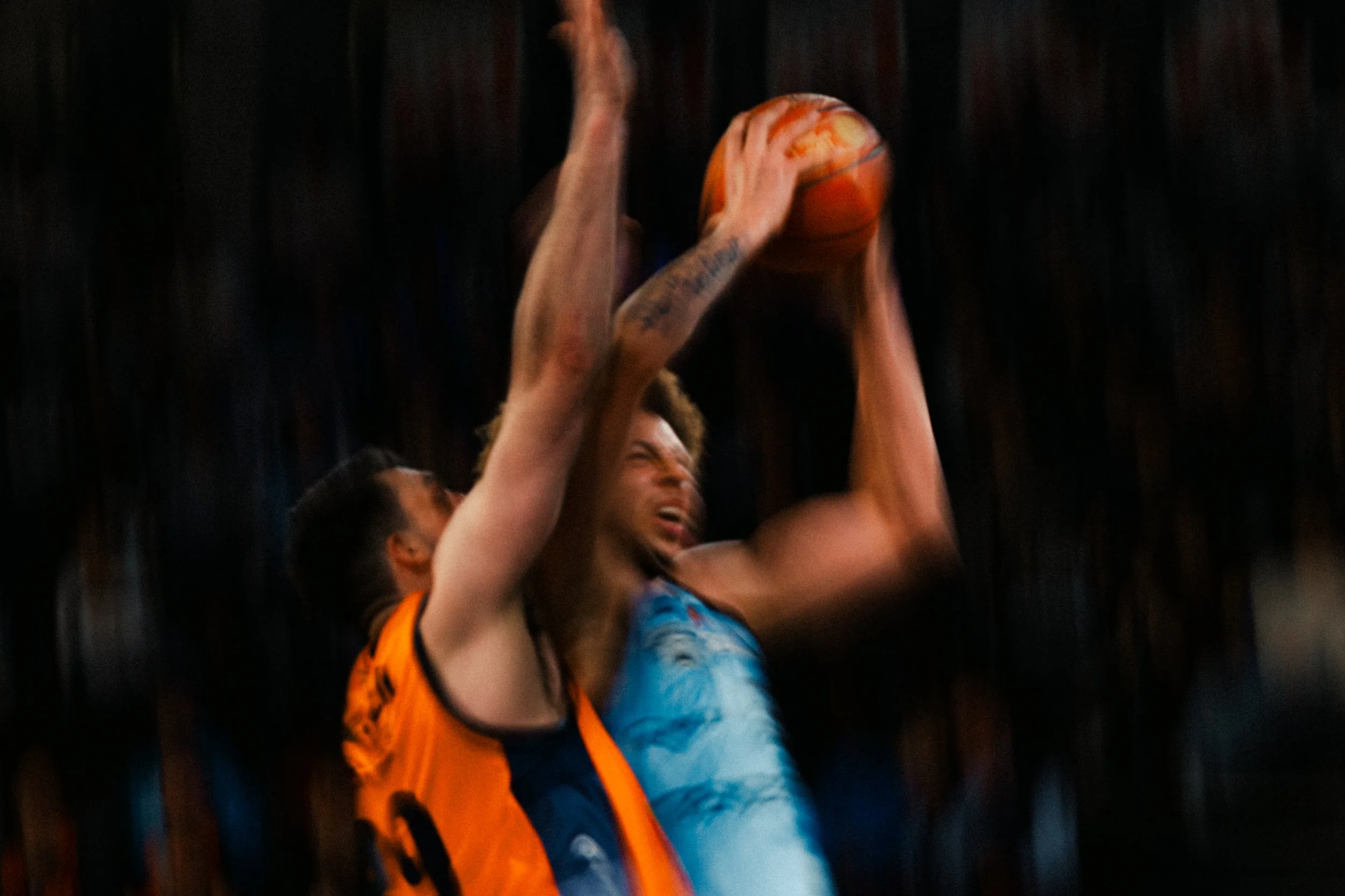 A basketball game in progress with two players jumping to catch the ball.