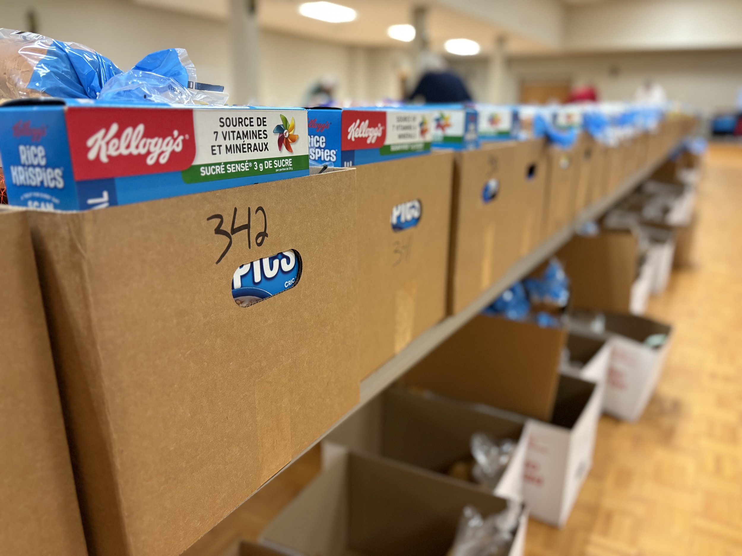 Close-up of cereal boxes on a store shelf, including Kellogg's Rice Krispies, with other boxes in the background.
